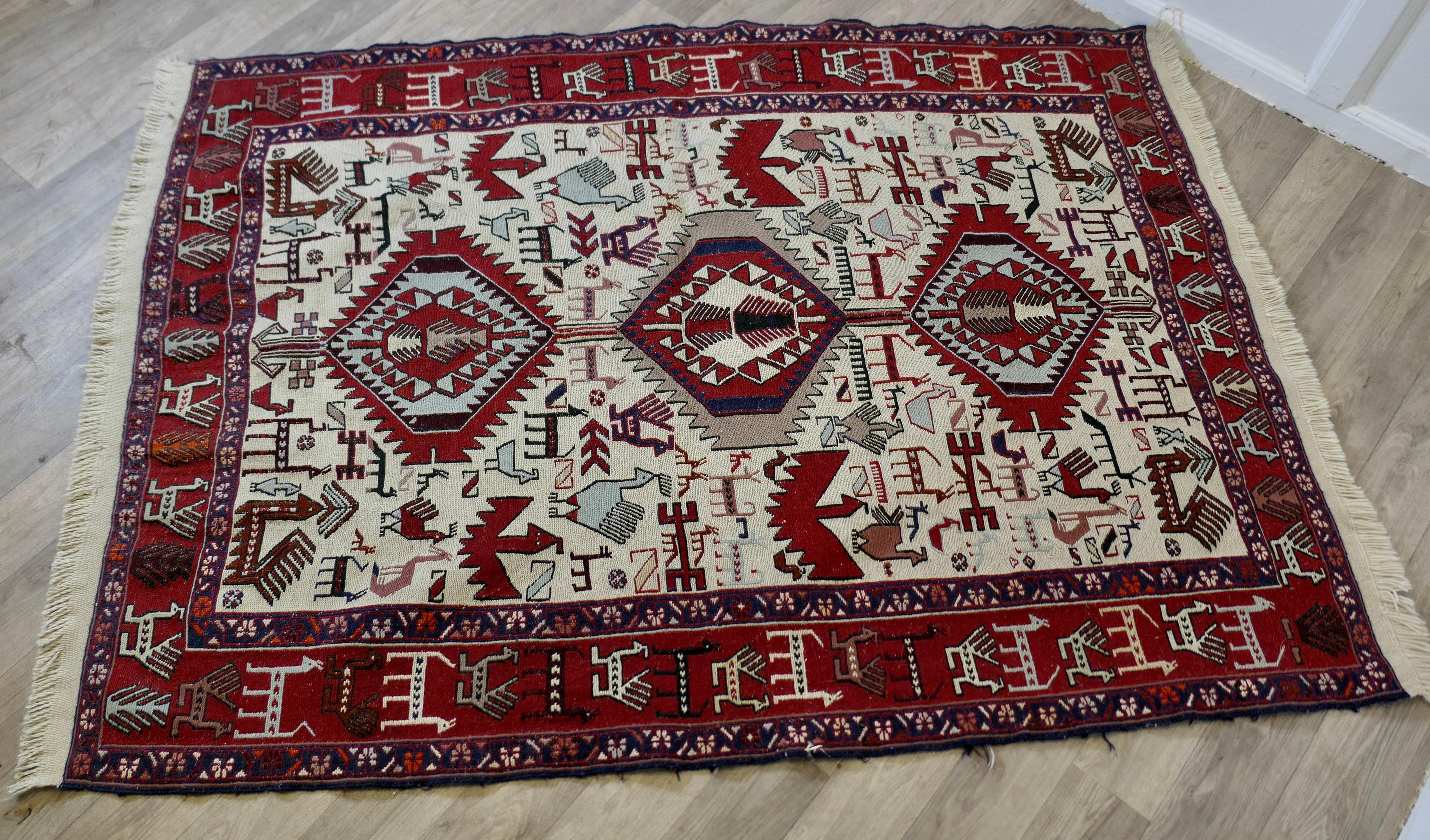Tapis ancien en laine tissé à la main
Une belle pièce avec une large bordure et décorée de nombreux animaux et oiseaux, principalement en rouge et écru.
Le tapis est en bon état et de couleurs vives, il mesure 64