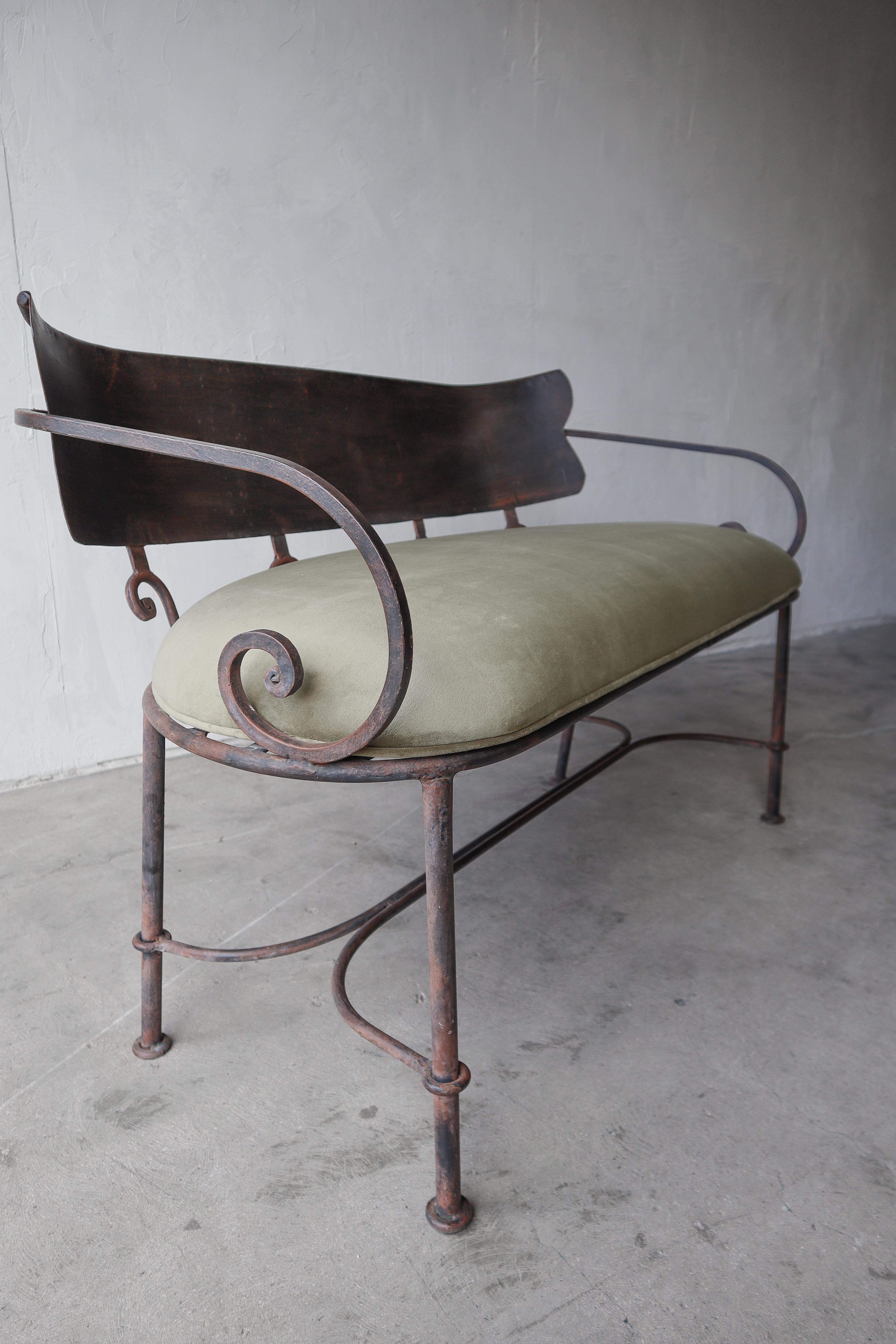 Beautiful antique iron bench settee. Bench has beautiful details, its truly a piece of art. It will add interest to many decor styles. It c an be used indoors with its custom upholstered seat or outdoor without it, showcasing its woven seat.