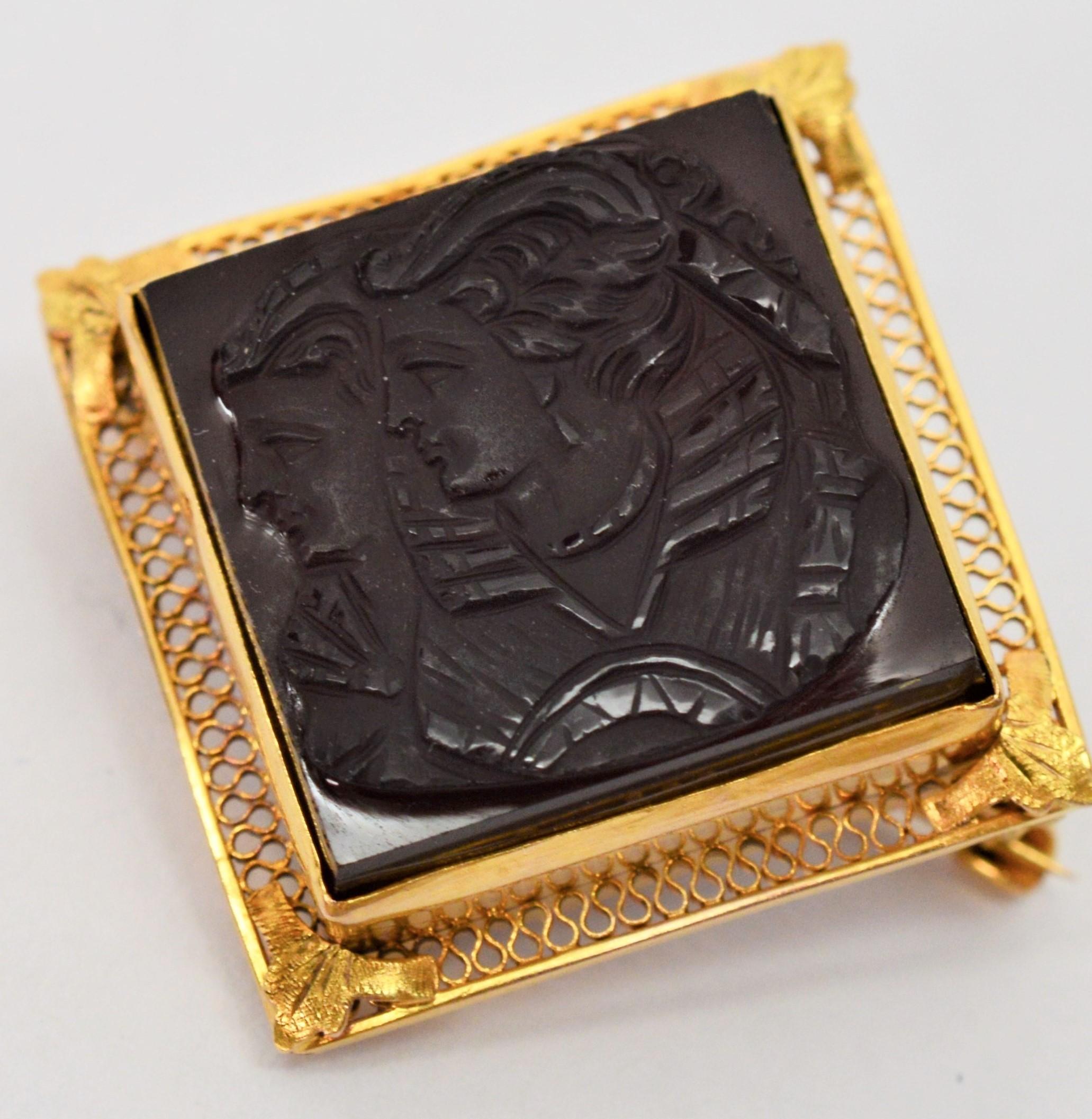 Fit for a queen, the fine detail of this romantic antique cameo brooch displays the portrait of a beautiful queen revealing her mirror image. Hand carved in regal rich onyx, the 15 mm x 15 mm stone is bezel set and impressively framed in ten karat