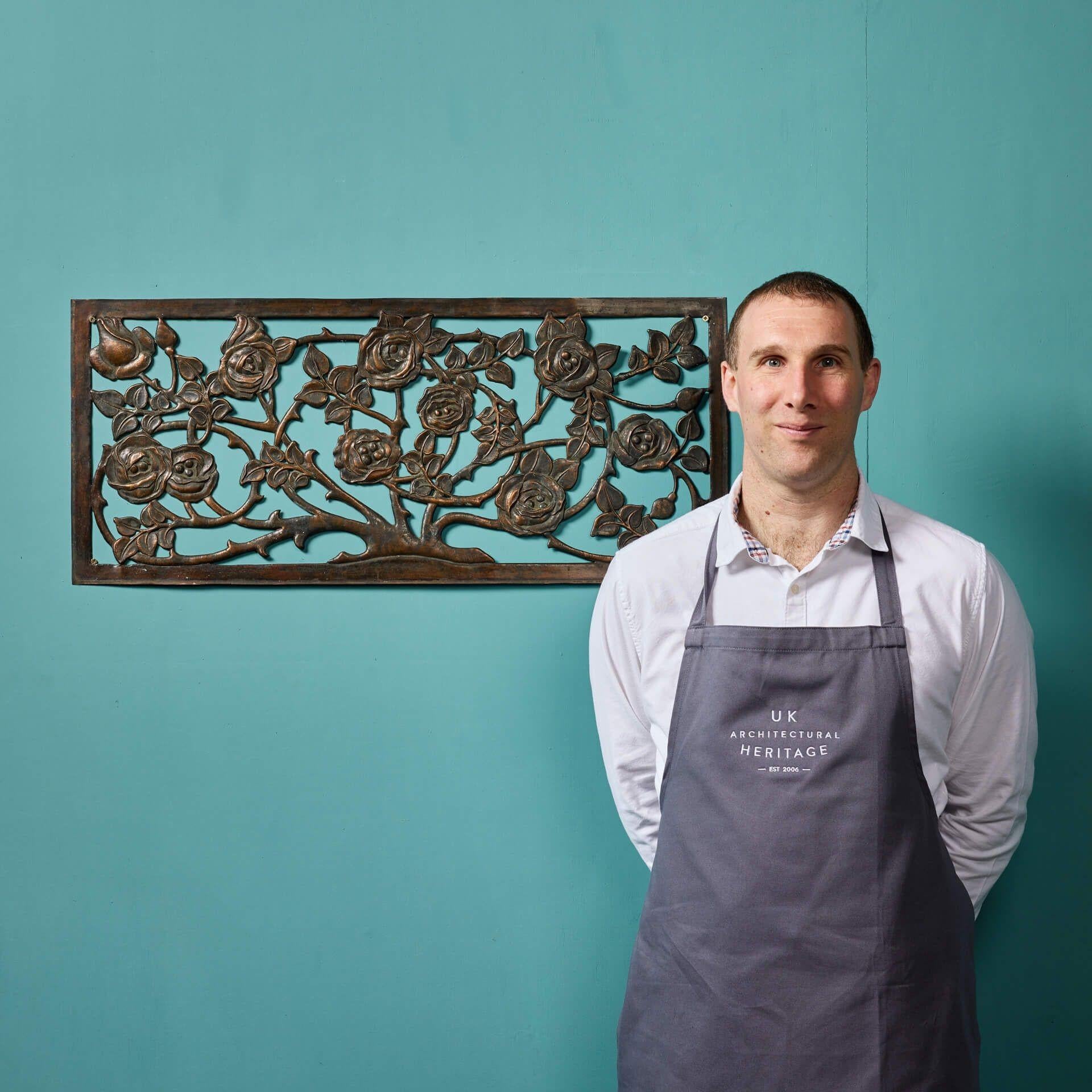 An antique handcrafted floral copper plaque, reclaimed from a country house in Somerset, England. Showcasing the French repoussé technique, this panel displays a hand-crafted detailed rose bush, accompanied by a strong copper patina finish. A