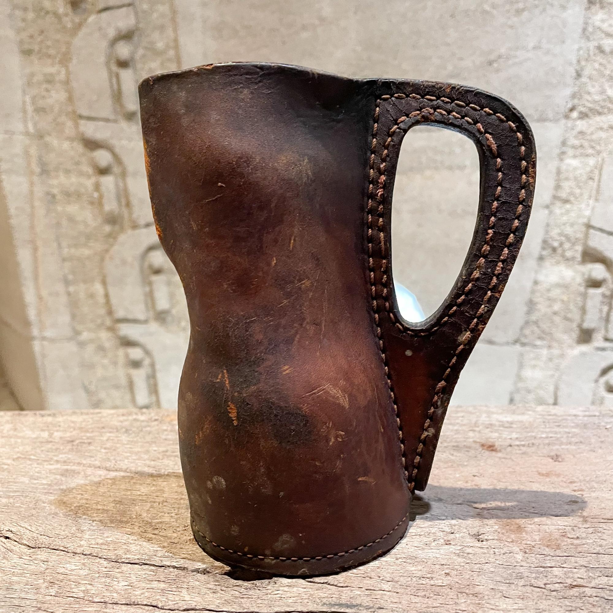 Antique handcrafted saddle leather Blackjack Pitcher jug vessel with contrast stitching 
Unmarked.
In the style of Hermes and Jacques Adnet.
Measures: 6.75 H x 5.25 D x 3.25 W inches
Original unrestored preowned condition. Untested vintage item.