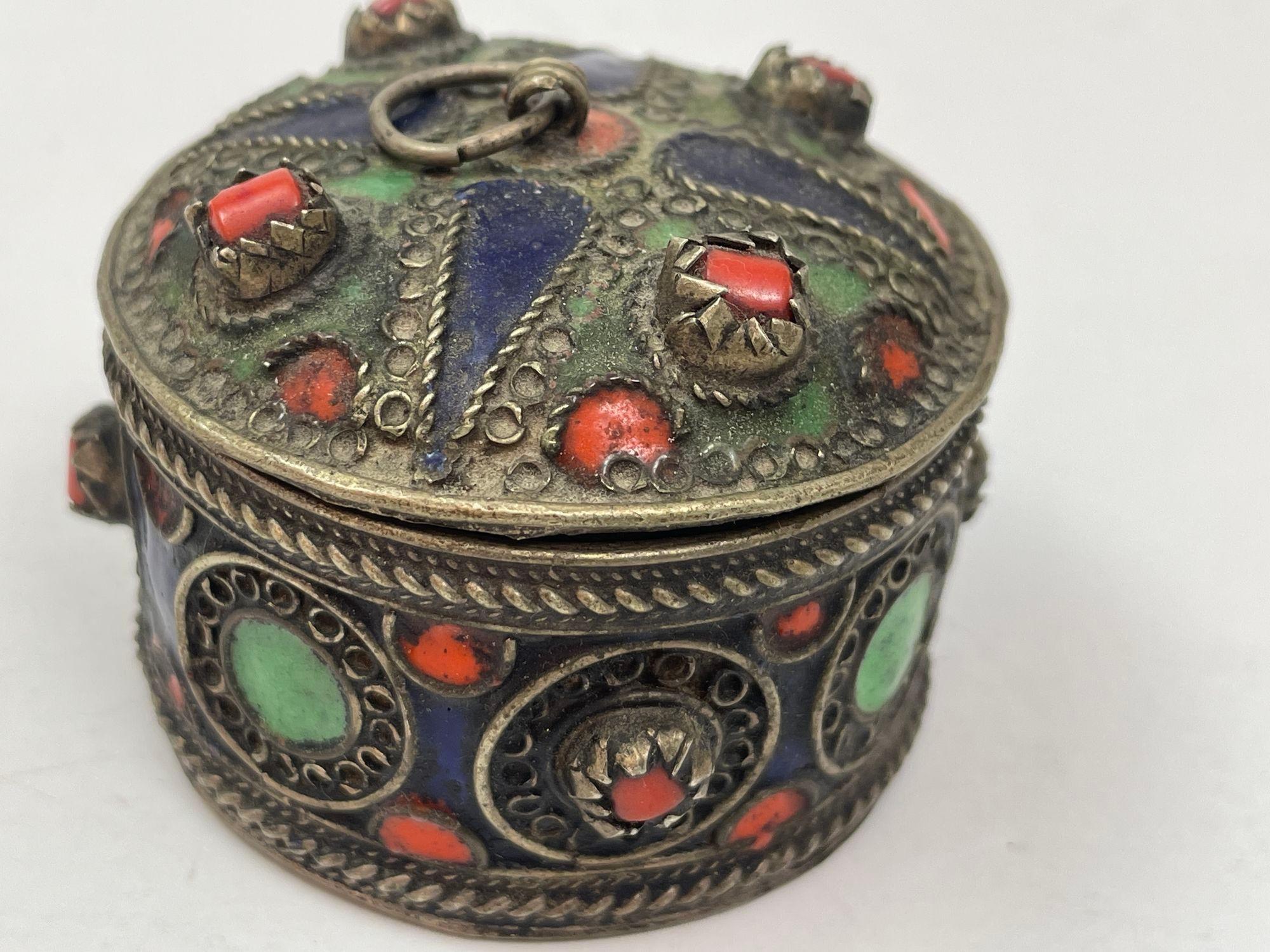Boîte berbère kabyle ancienne, fabriquée à la main.
Fabrication artisanale vintage d'Afrique du Nord.
Boîte berbère kabyle d'Algérie en maillechort réalisée dans le style traditionnel des émaux rouges et verts et sertie de perles rouges.
Les femmes