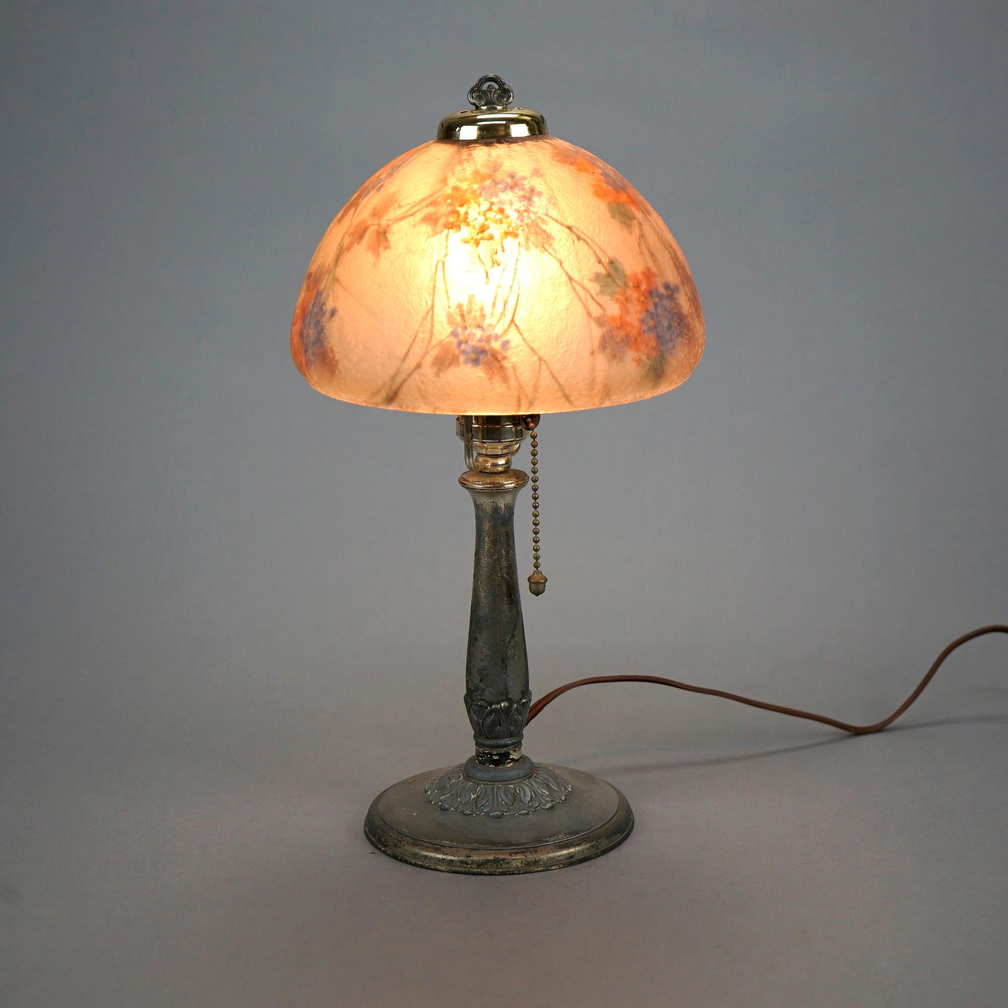 An antique boudoir lamp by Handel offers floral reverse painted dome form glass shade over single socket cast base, shade signed and base with maker label as photographed, c1920

Measures- 14.25''H x 7.25''W x 7.5''D.