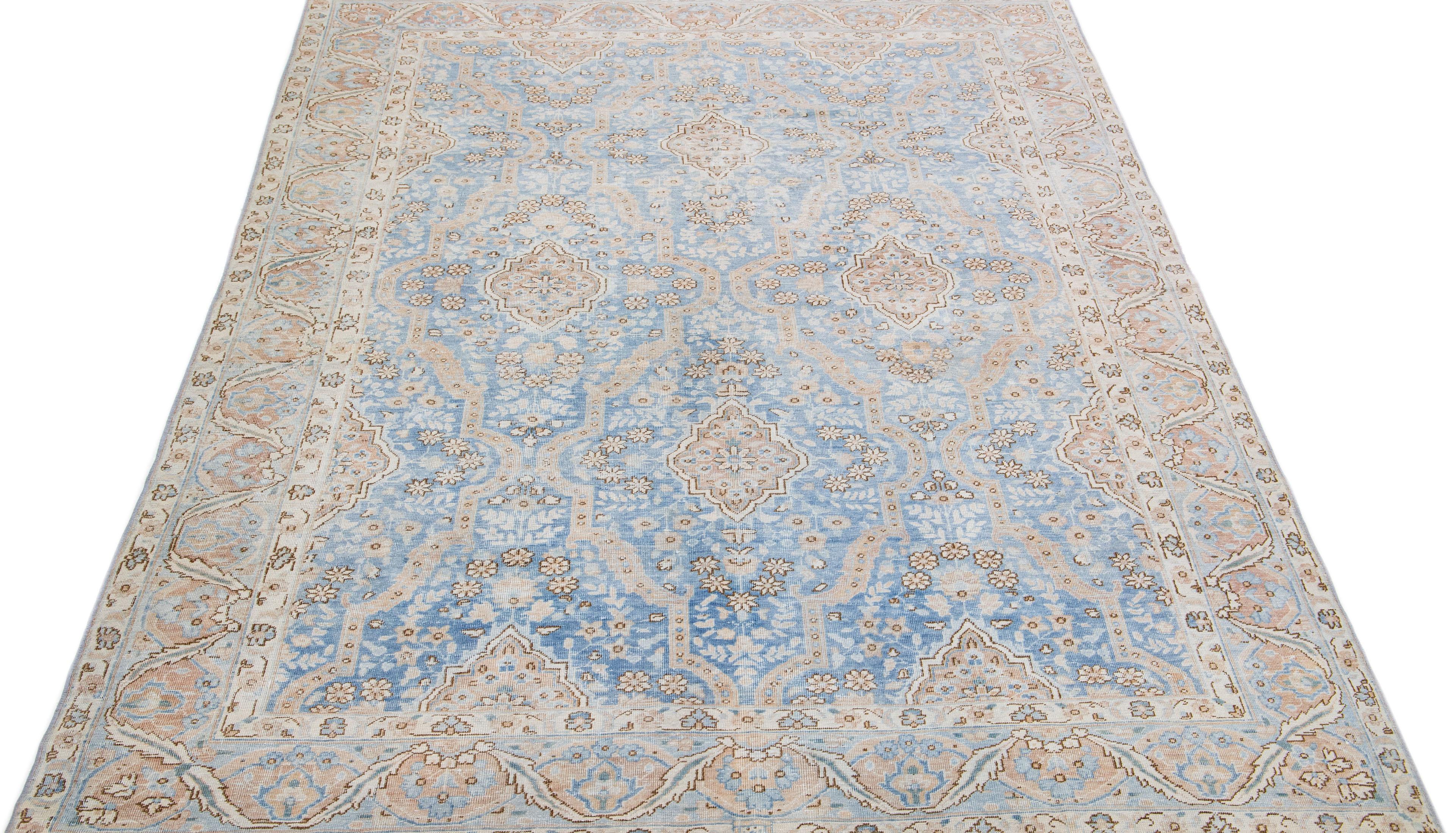 Beautiful antique Tabriz hand-knotted wool rug with a blue color field. This Persian rug has a designed frame with brown and beige accents in a gorgeous all-over floral design.

This rug measures: 6'5