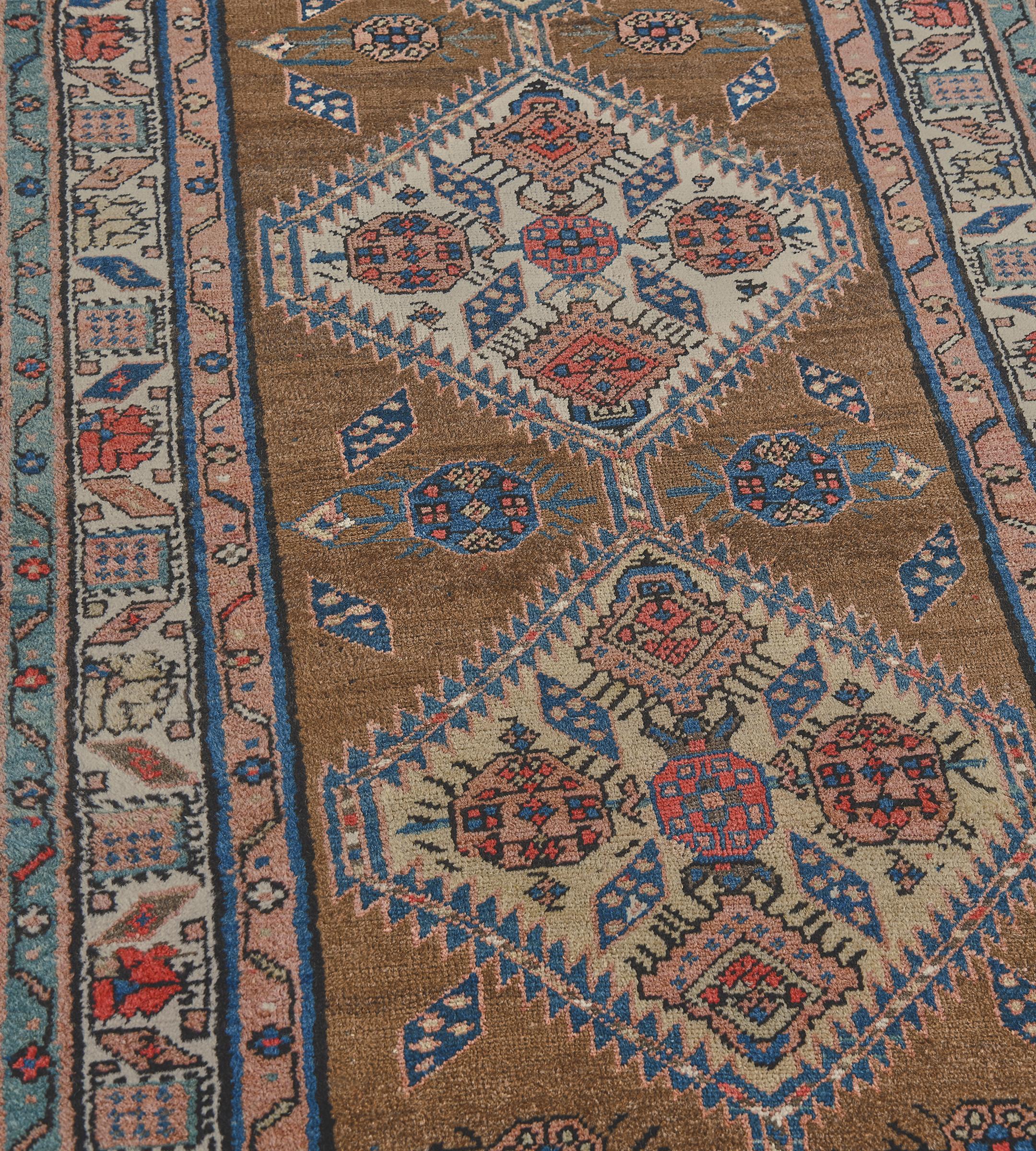 This antique, circa 1900, Persian Serab runner has a shaded camel-brown field with a vertical row of linked serrated golden-yellow alternating with ivory lozenges each containing a central rosette lozenge issuing four polychrome lozenges with four