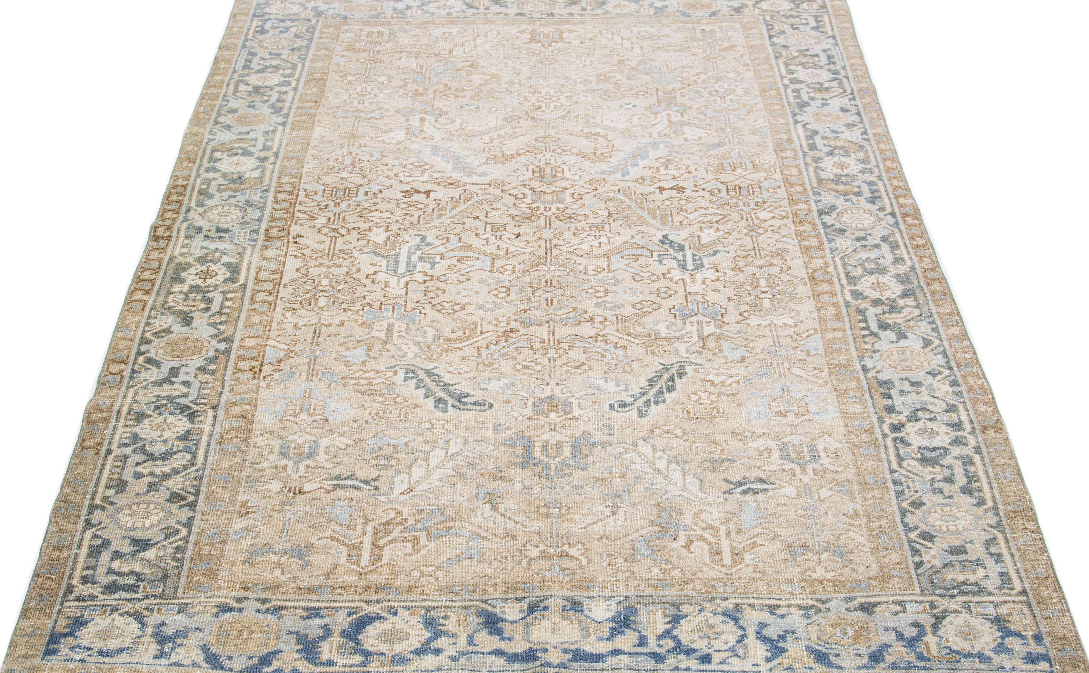 Beautiful antique Heriz hand-knotted wool rug with a beige color field. This Persian rug has a blue frame and accents in a gorgeous all-over geometric floral design.

This rug measures: 7'3