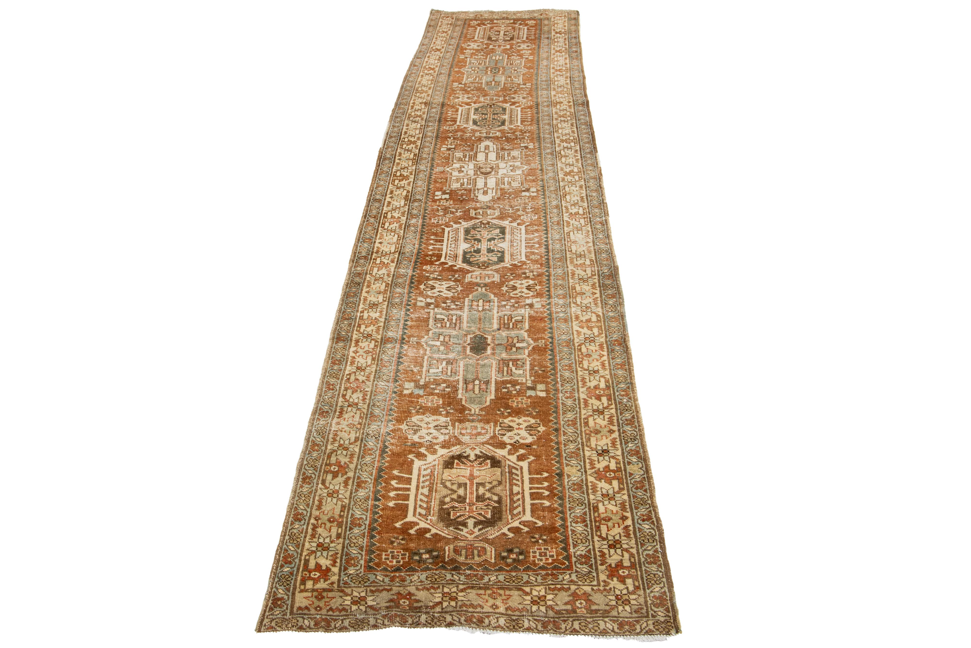 This beautiful 20th-century Heriz hand-knotted wool runner has an orange field. The piece features stunning blue, brown, and beige accents in a gorgeous tribal design.

This rug measures 2'9
