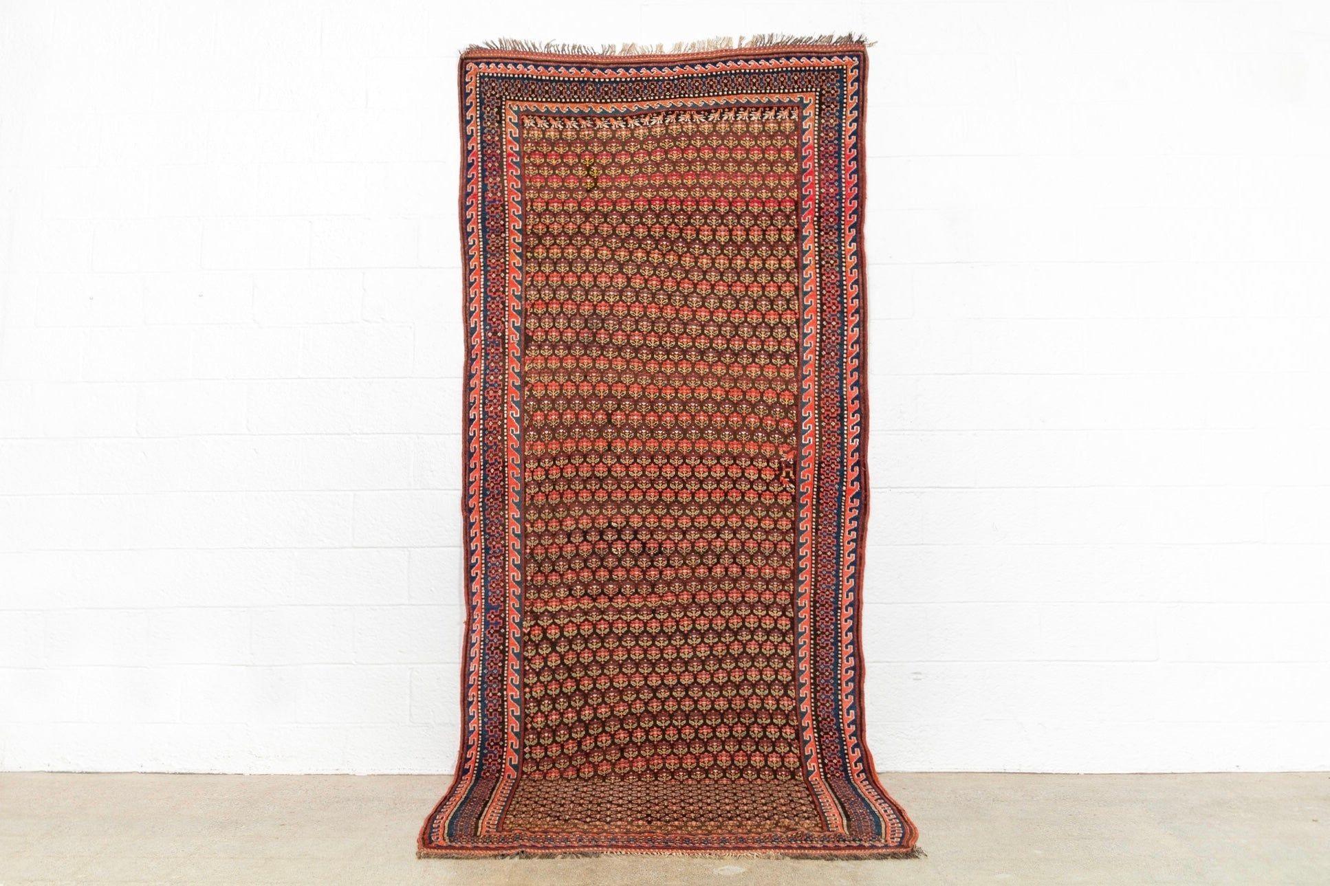 Questo elegante tappeto curdo antico, risalente alla fine del 1800, è sapientemente annodato a mano in 100% lana tinta naturalmente. Sfoggia un classico stile persiano con un motivo geometrico e floreale incredibilmente intricato, circondato da un