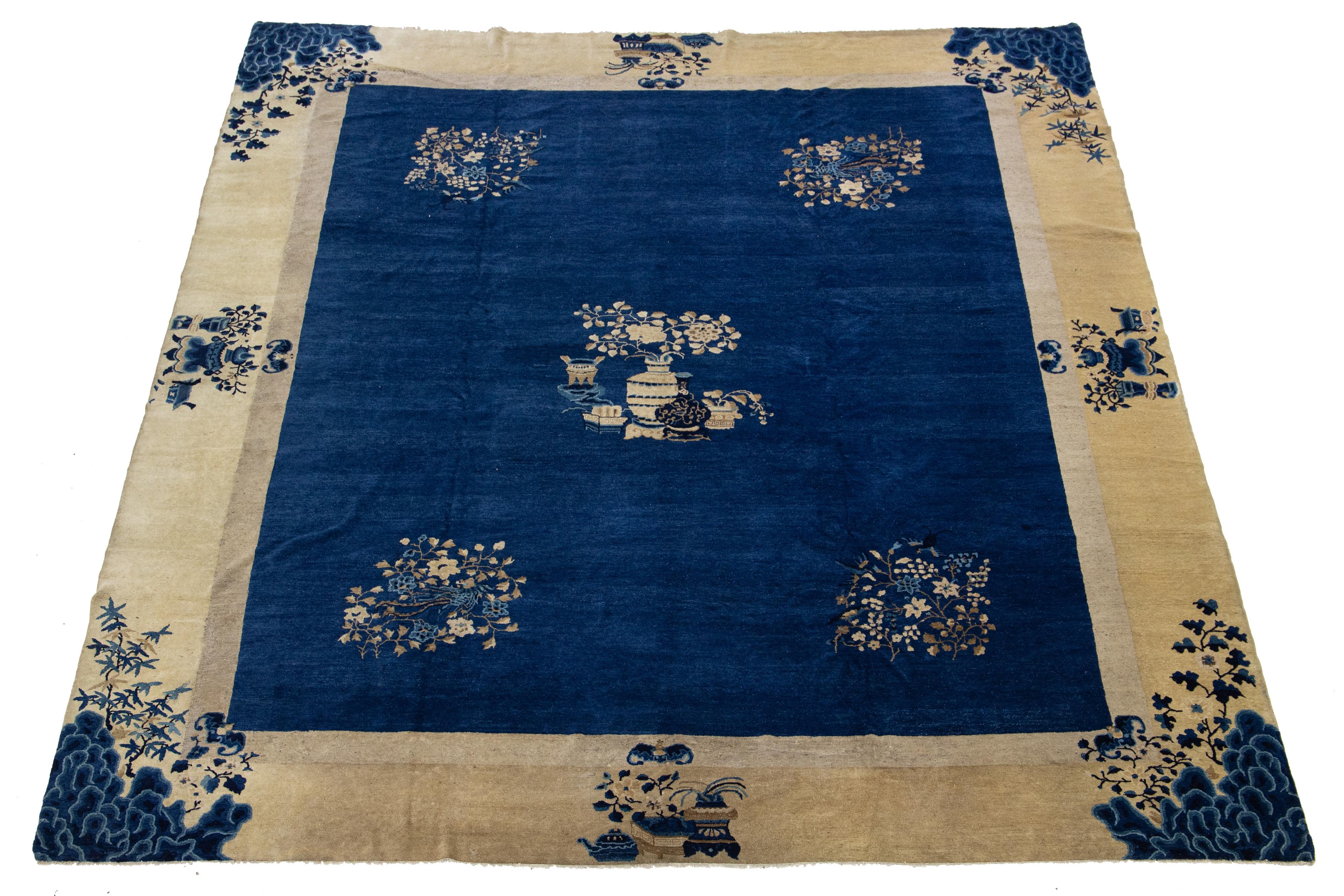 Dieser außergewöhnliche antike chinesische Art-Déco-Teppich wurde in sorgfältiger Handarbeit aus hochwertiger Wolle geknüpft. Es zeigt einen sattblauen Hintergrund, der mit einem eleganten Blumenmuster in Beige verziert ist, das von einer