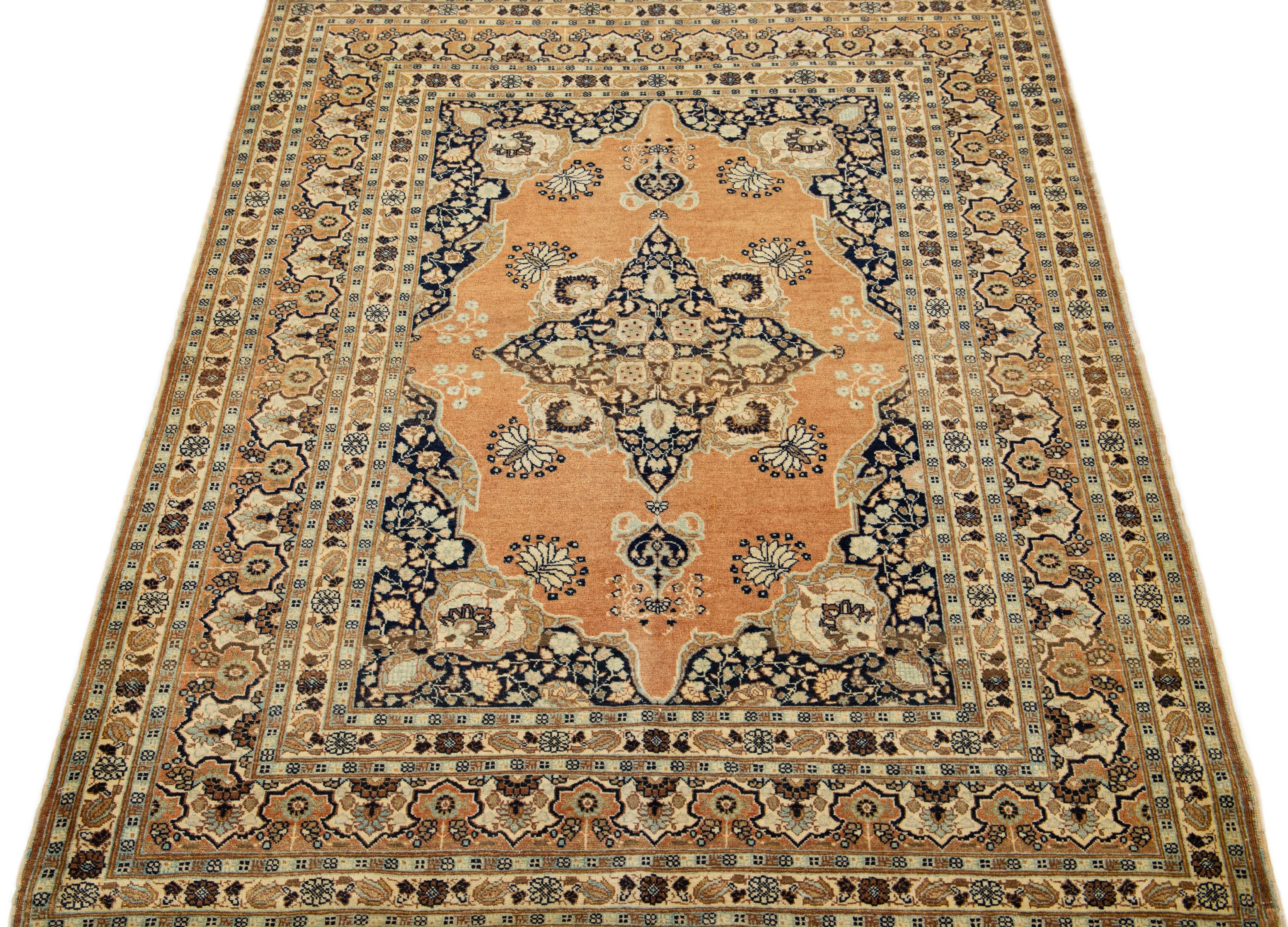 This Persian Tabriz wool rug showcases an exquisite traditional floral medallion design with a striking tan accent against a beige, blue, and brown background. 

This rug measures 4'3