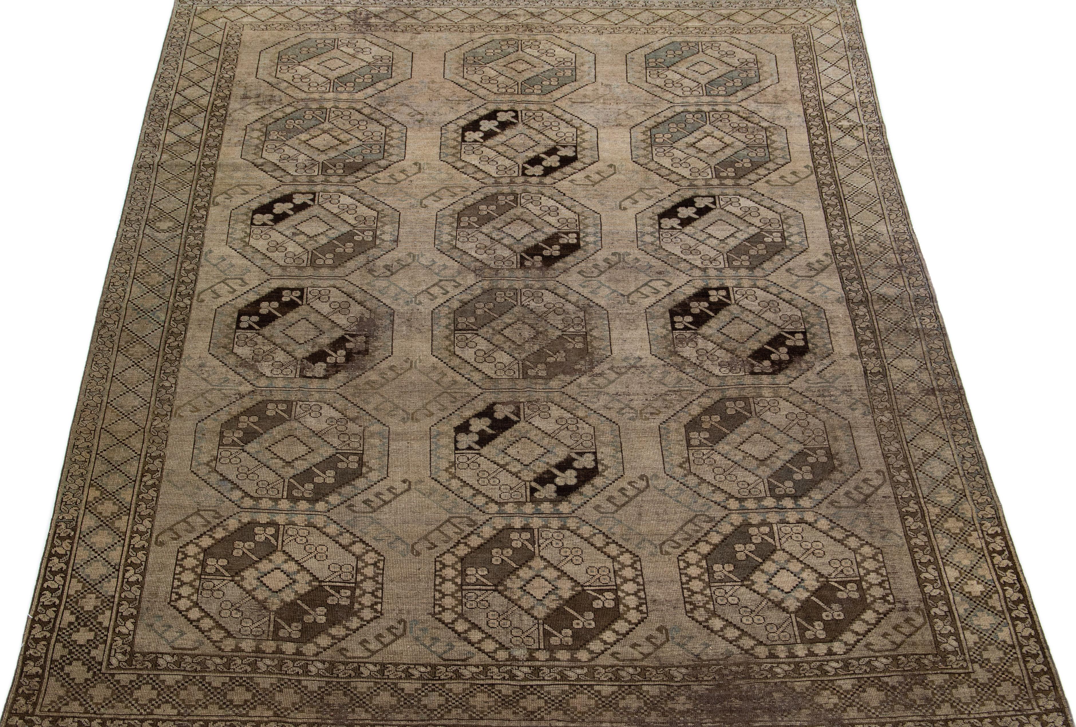 Schöner antiker turkmenischer handgeknüpfter Wollteppich mit einem hellbraunen Farbfeld. Dieses persische Stück hat ein wunderschönes Gul-Muster-Muster in Grün und Blau.

Dieser Teppich misst: 7'3