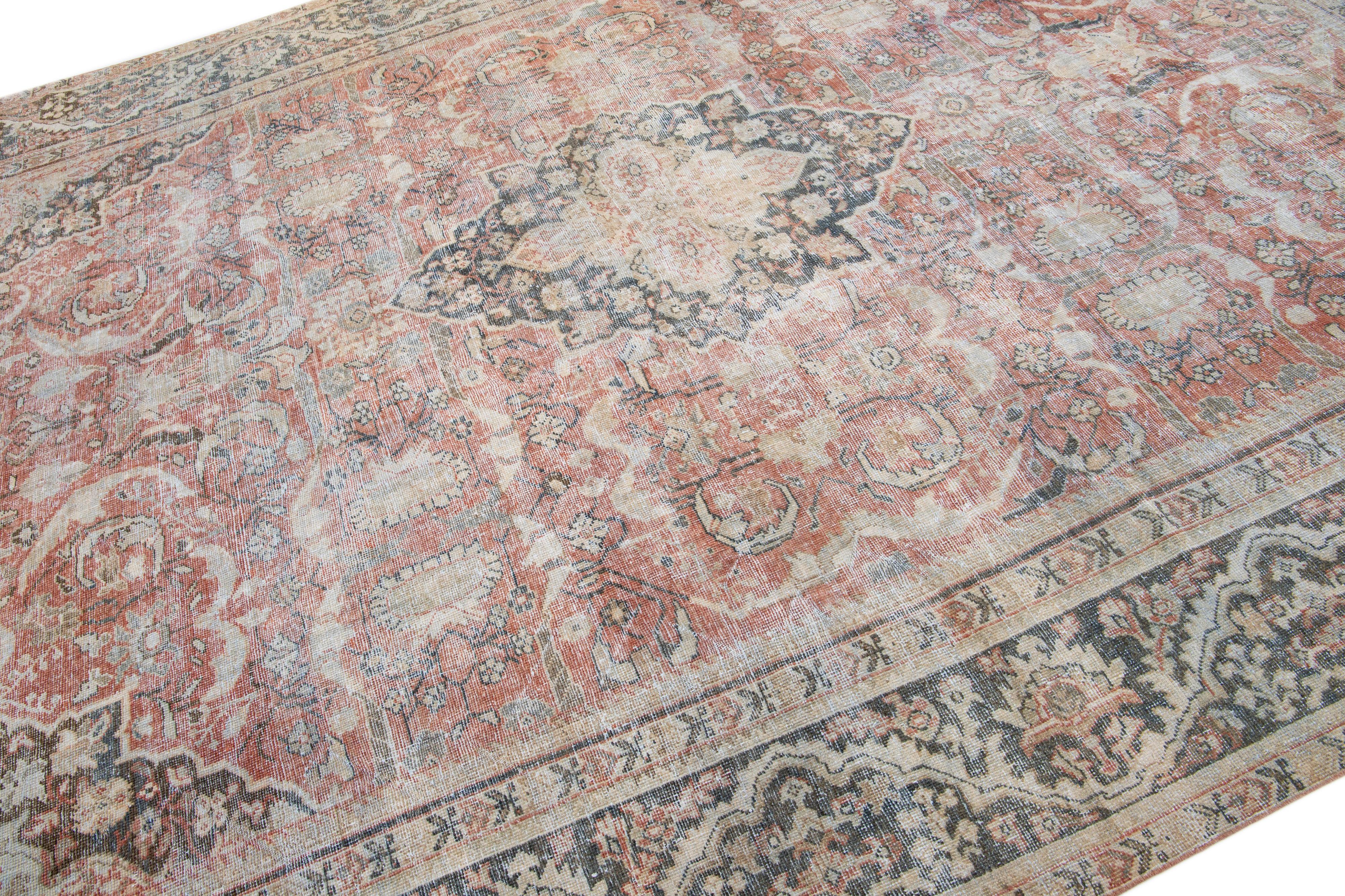 Ce magnifique tapis mahal en laine des années 1920 présente un champ principal de couleur rouille et des couleurs secondaires de bleu, beige et brun dans un motif traditionnel de médaillon floral. Son nouage complexe à la main en fait une pièce