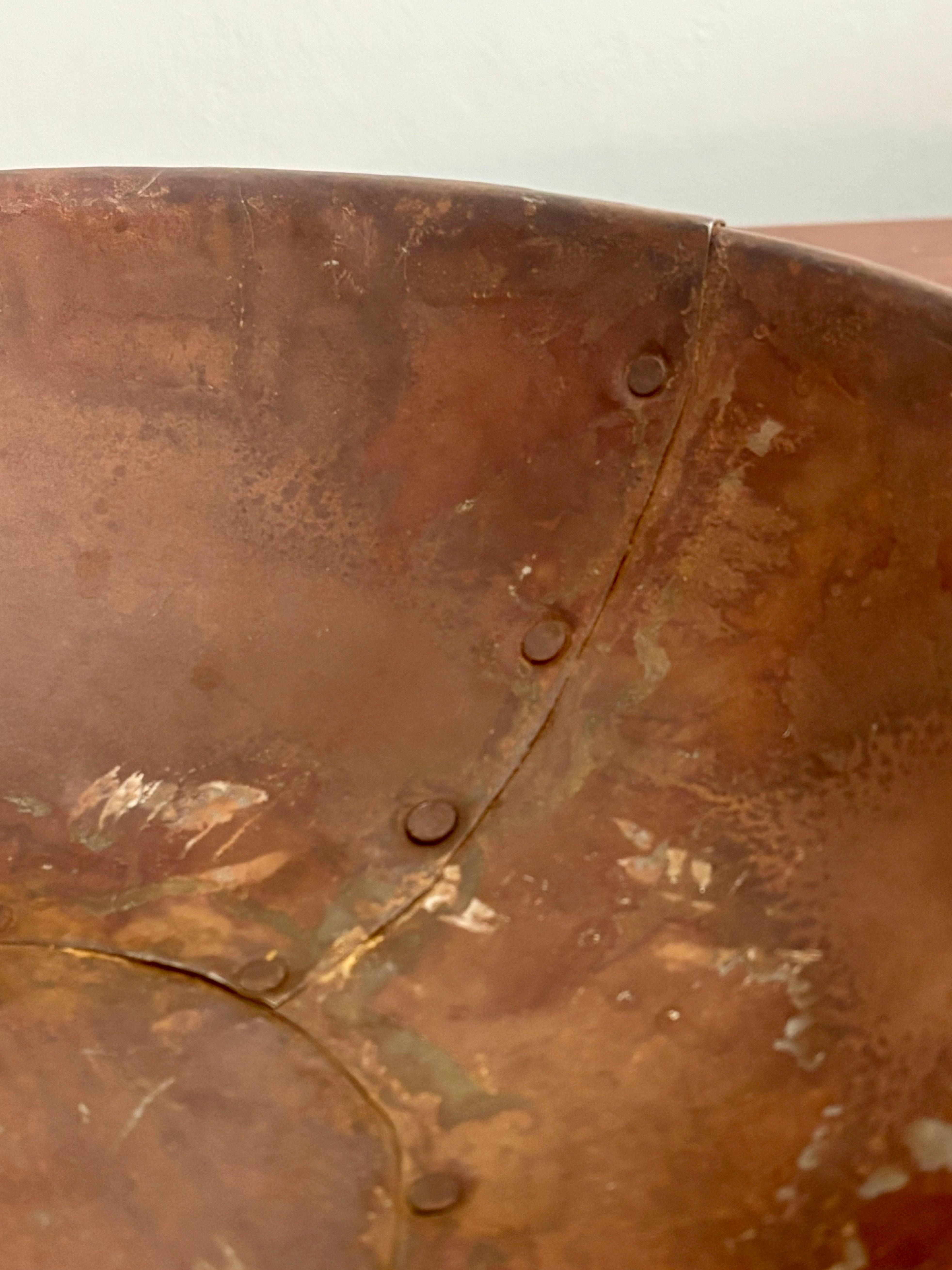 A beautiful antique copper mixing bowl. 

Made with hand cut pieces that have been riveted together by the maker. Two rings on either side for carrying. 

19th century or potentially earlier. You can tell this was a piece that was made to be used