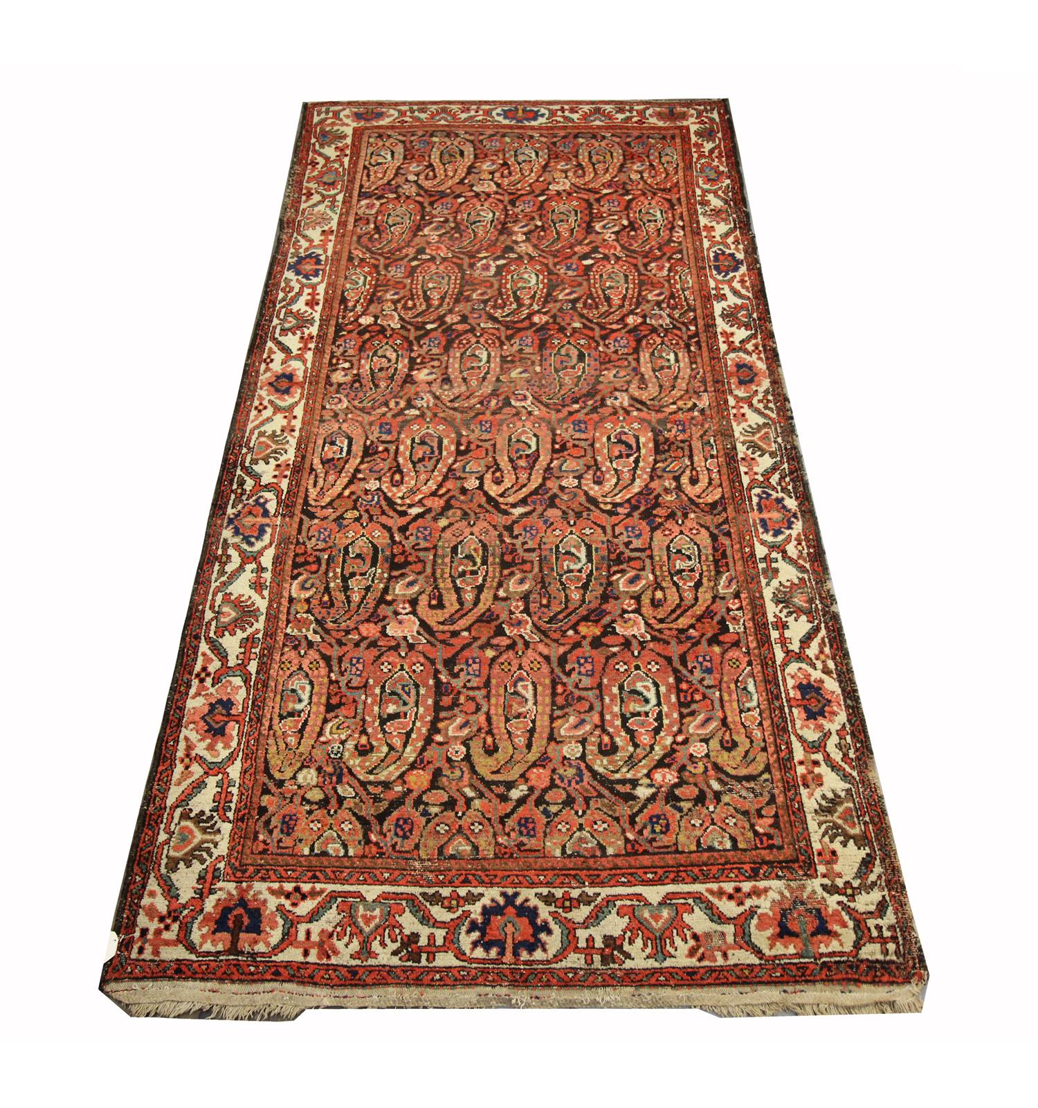 This fine wool area rug is an excellent example of antique rugs woven in Azerbaijan in the 1880s. The design features a bold paisley print woven in rich red, beige, blue and orange on a contrasting background. The shapes and patterns in this piece