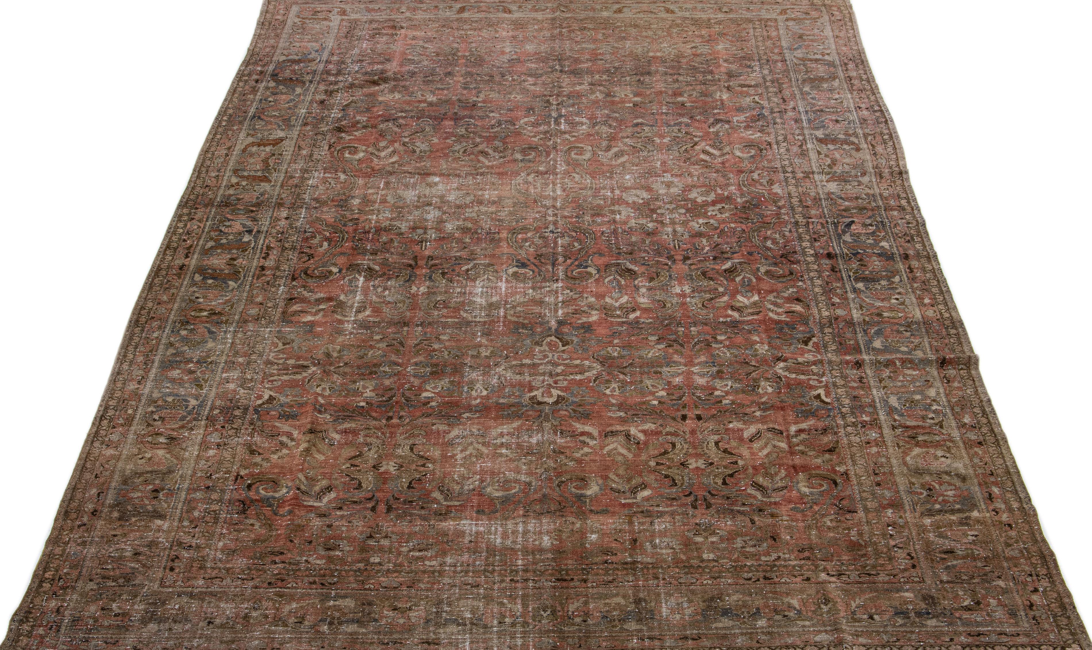 Beautiful Antique Malayer hand-knotted wool rug with a red-rust color field. This Persian rug has gray and brown accents in an all-over floral design.

This rug measures 10'2