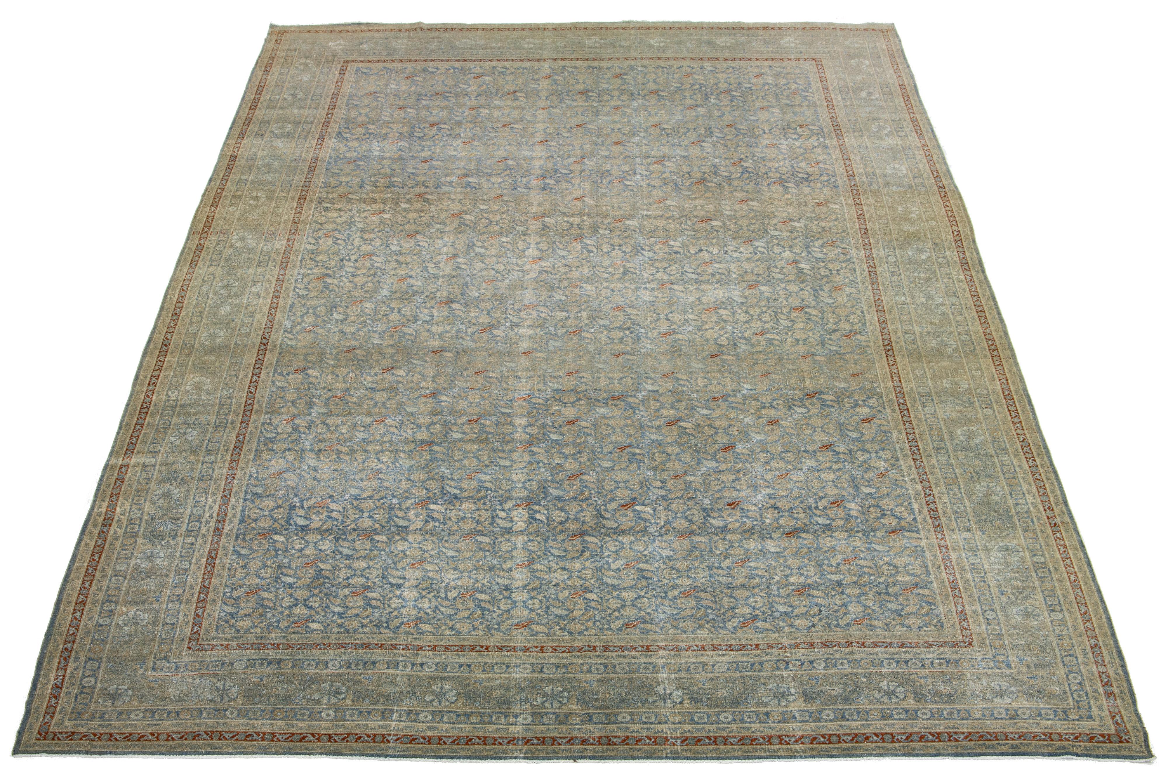 This Persian Tabriz wool rug is handcrafted and features a classic all-over floral pattern on a blue background with shades of orange and light brown.

This rug measures  13'4