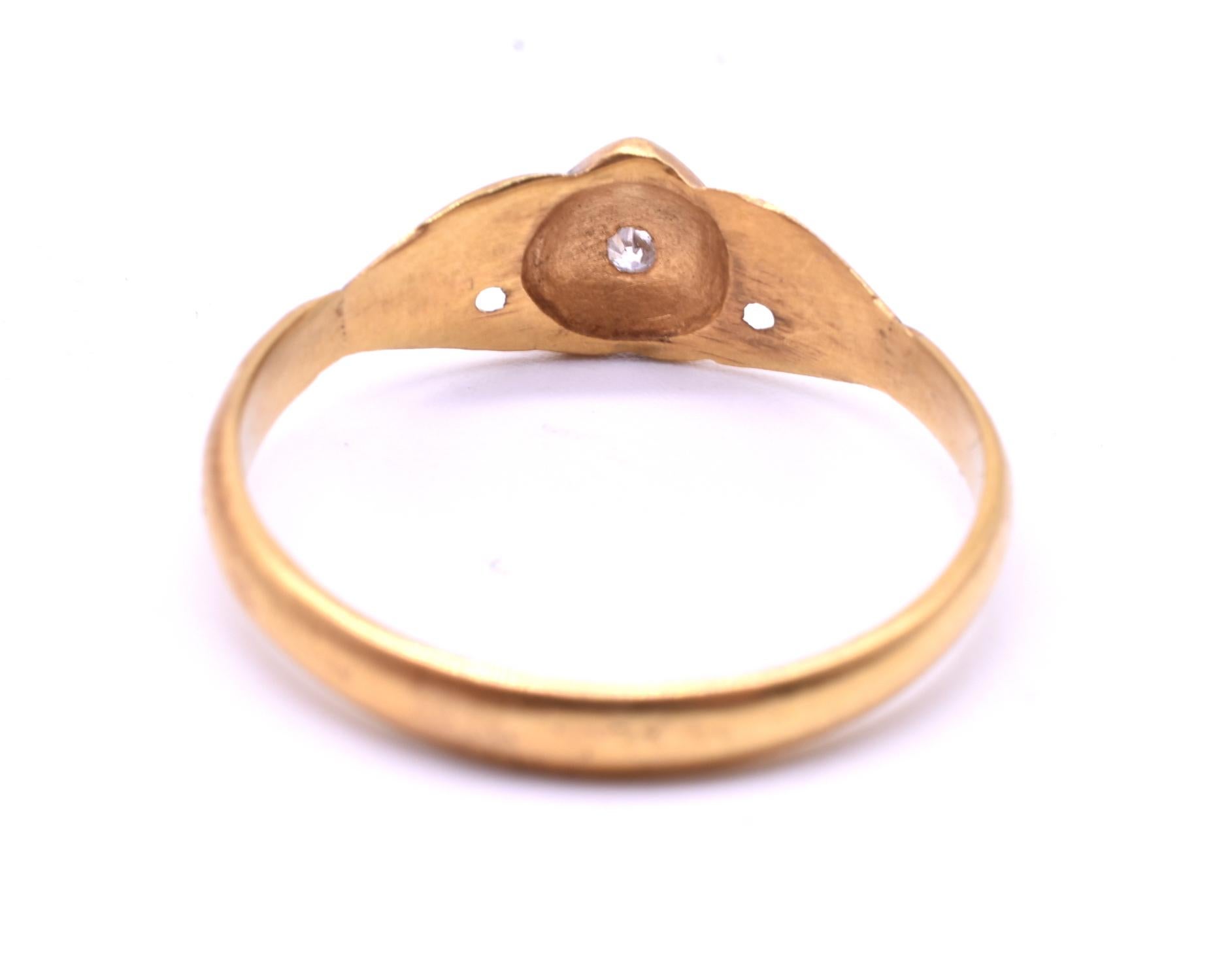 15K gold fede or love ring with two hands coming together to enclose a gold heart with a single rose-cut diamond embedded in a carved star at the center. The word 