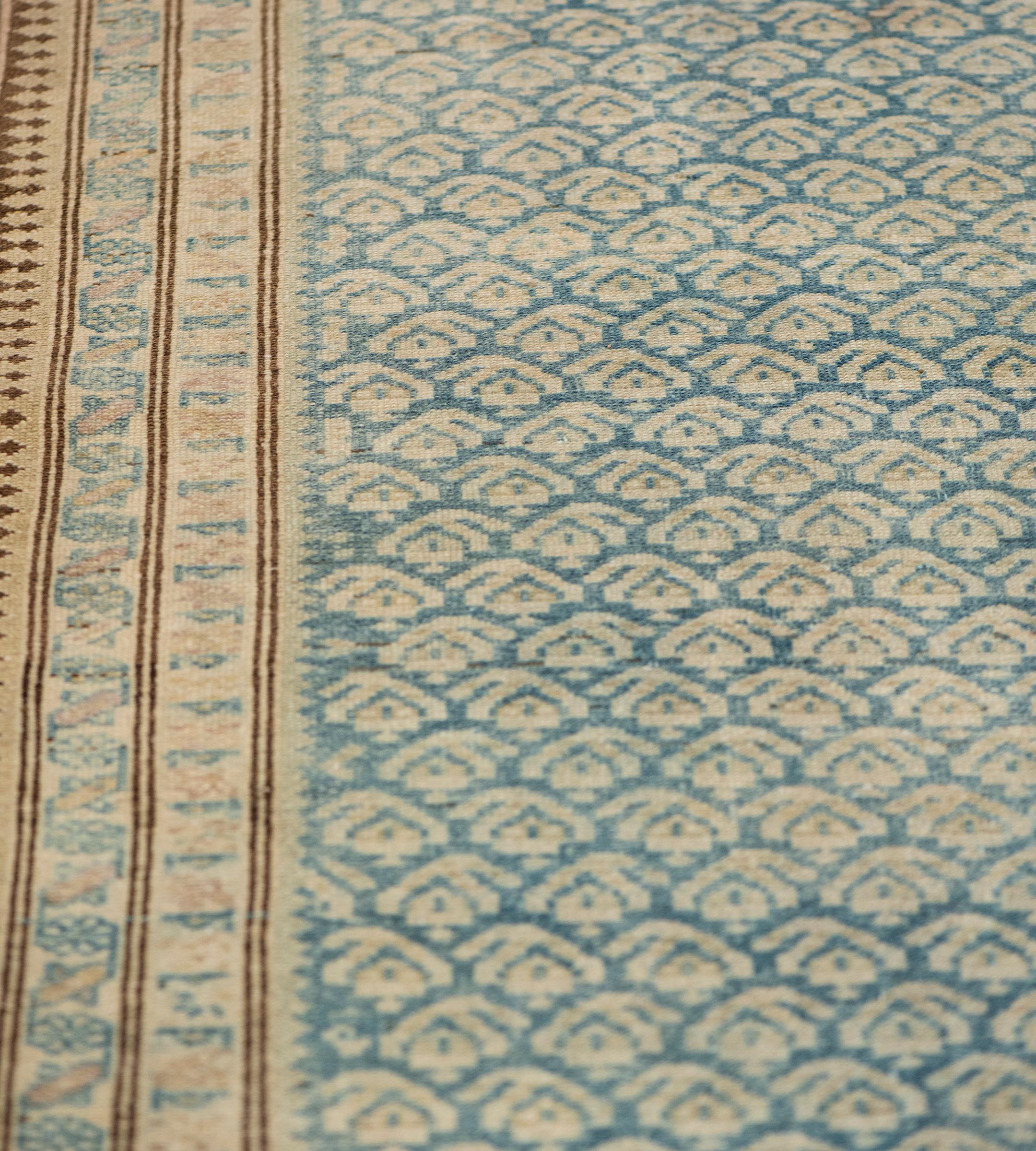 This antique Malayer runner has a shaded sea-blue field with an overall pattern of diagonal rows of sandy-yellow boteh motifs, in an ivory border of floral lozenge vine between ivory floral, buff and chocolate brown reciprocal skittle-pattern