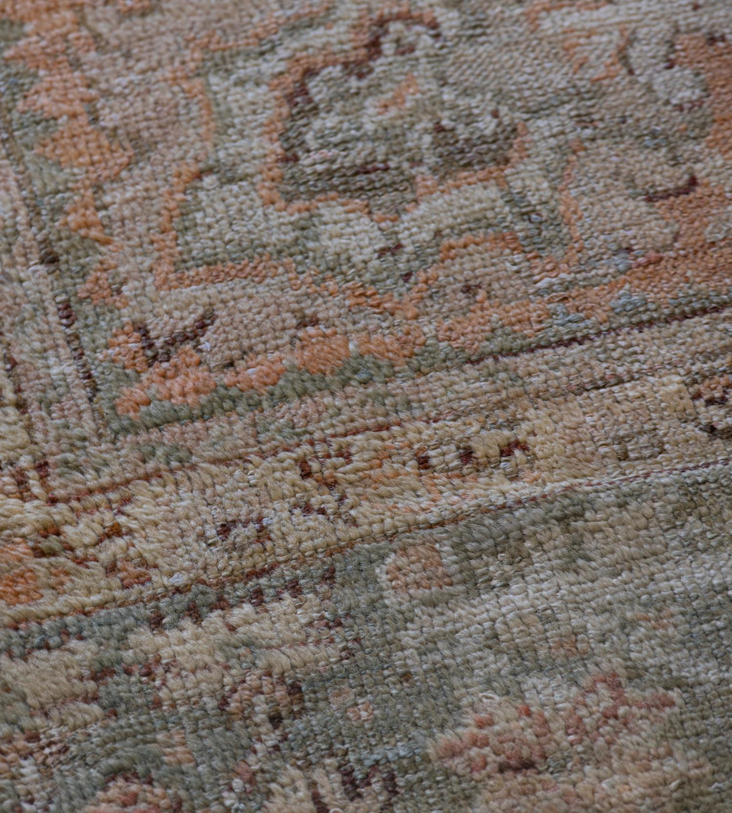 The shaded terracotta-red field with an overall angular palmette, serrated leaf and flower head vine, in a shaded light blue angular floral vine border between ivory floral vine stripes, plain shaded light-terracotta-red stripe.

Oushak (or Ushak)
