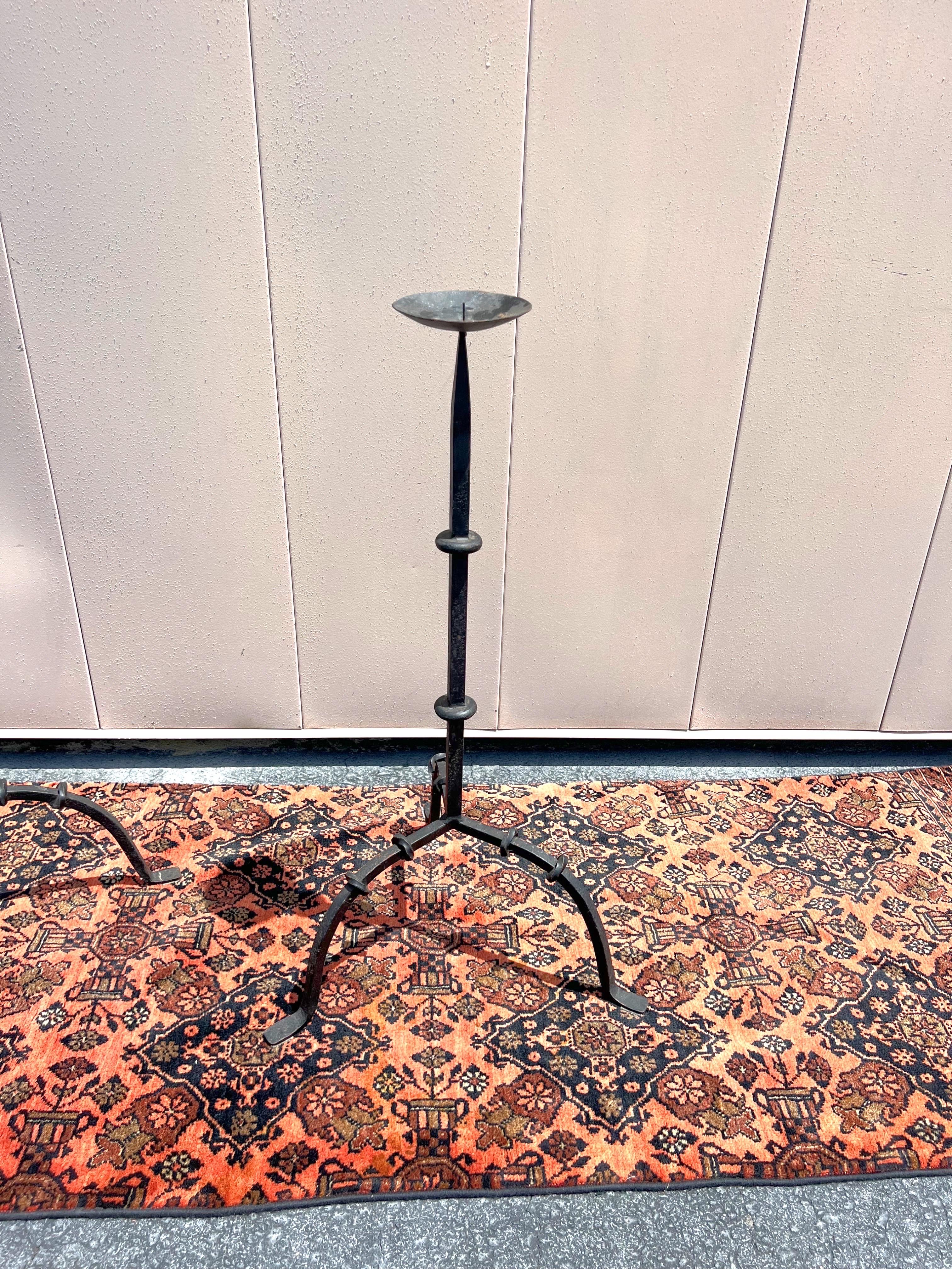 A wonderful pair of Antique 19th Century French style hand forged iron candle stands.  They put off a statement with their simple design.  C. 19th century 
Tall measures: 41” tall x 17” circumference at the base
Smaller one measures: 30.25” tall x