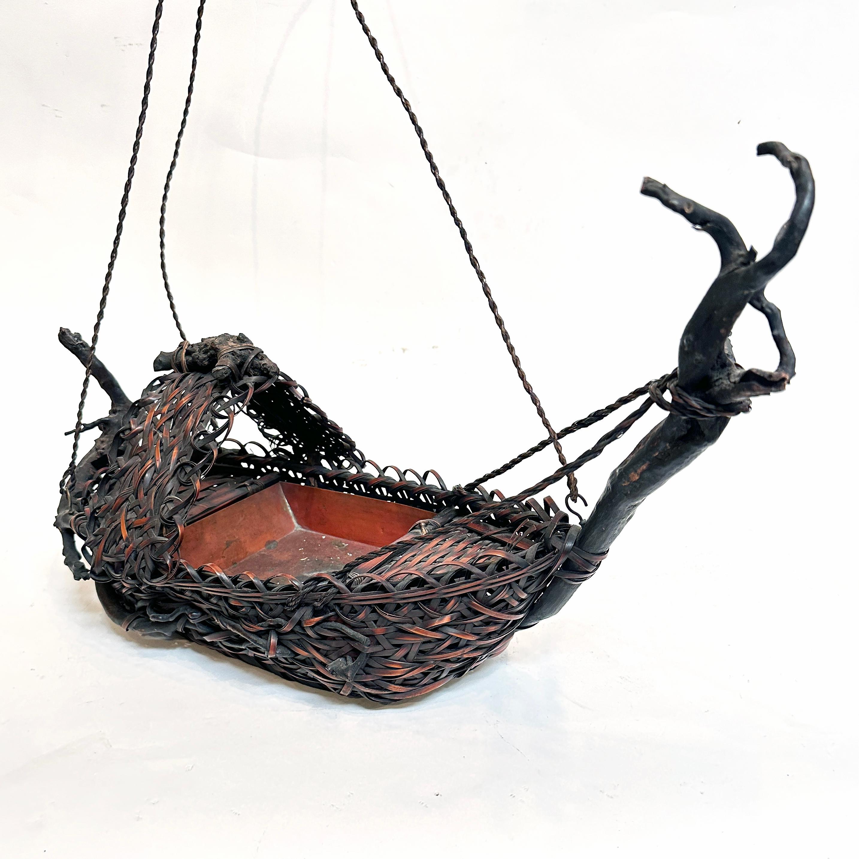 Cestino Ikebana a forma di barca, l'arte giapponese della composizione floreale. Realizzato in bambù con inserto in rame, firma del produttore. Questo cesto ikebana unico nel suo genere presenta un intreccio irregolare di strisce di bambù e accenti