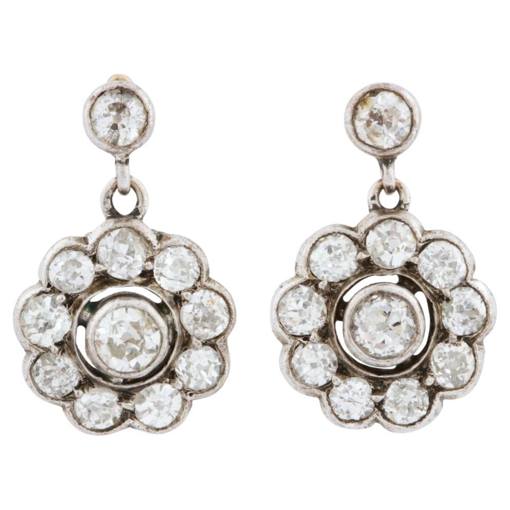 Boucles d'oreilles suspendues anciennes avec des diamants en forme de fleurs.