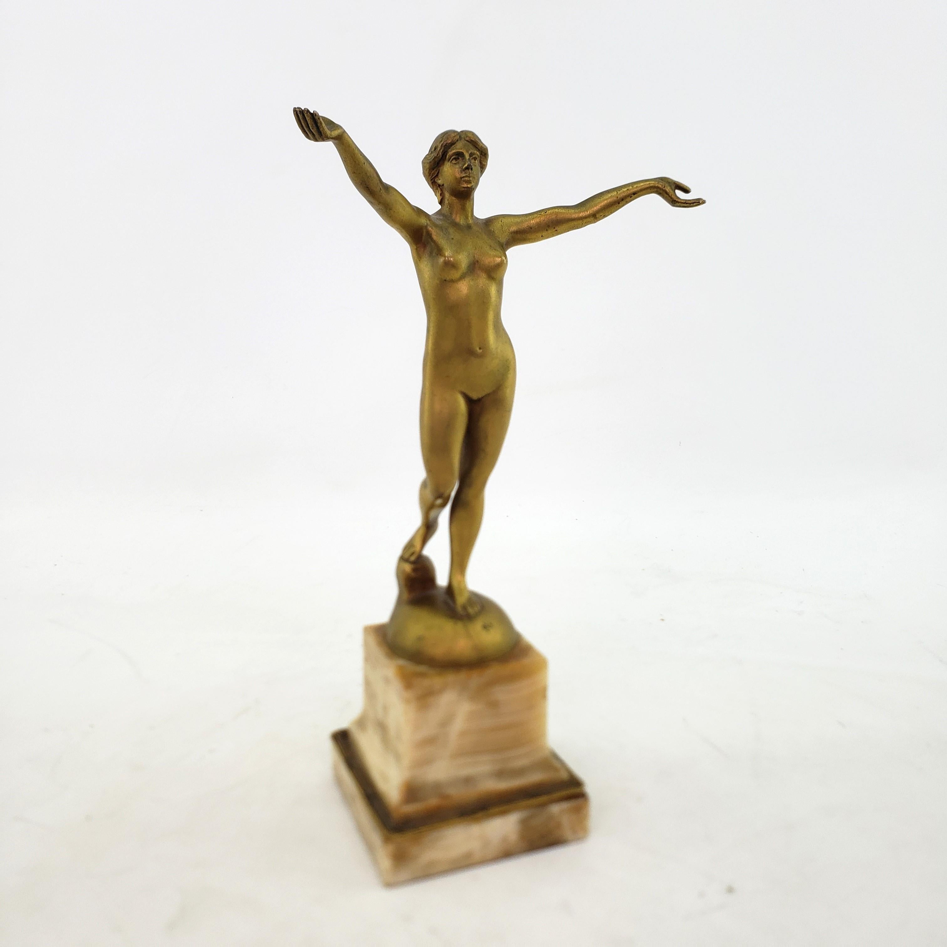 This antique sculpture was done by the well known Hans Arnoldt of Germany and dates to the early 20th Century and done in an Art Deco style. The sculpture is composed of cast and patinated bronze and depicts and standing nude female with oustretched