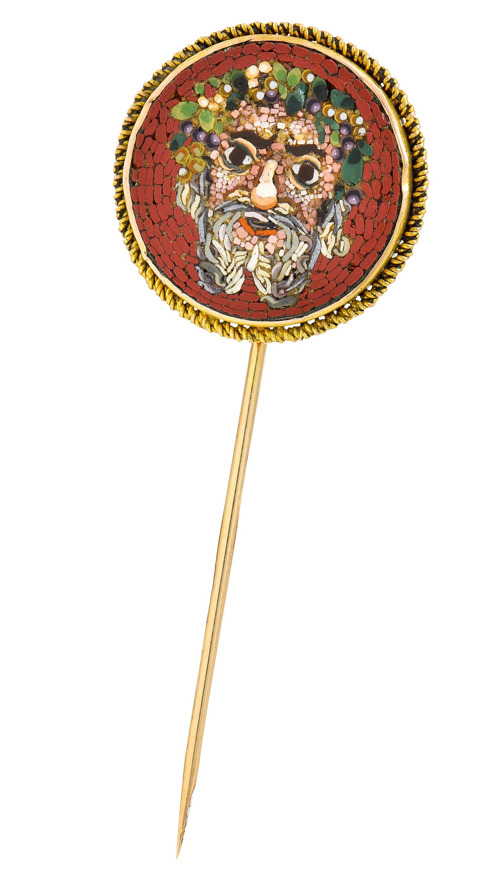 Stickpin centers intricately inlaid hardstone micro-mosaic depicting the head of the god Dionysus

Adorned with grape vine crown on an orangey-red background

Ranging in color with green, purple, peach, and gray - quality consistent with age

With