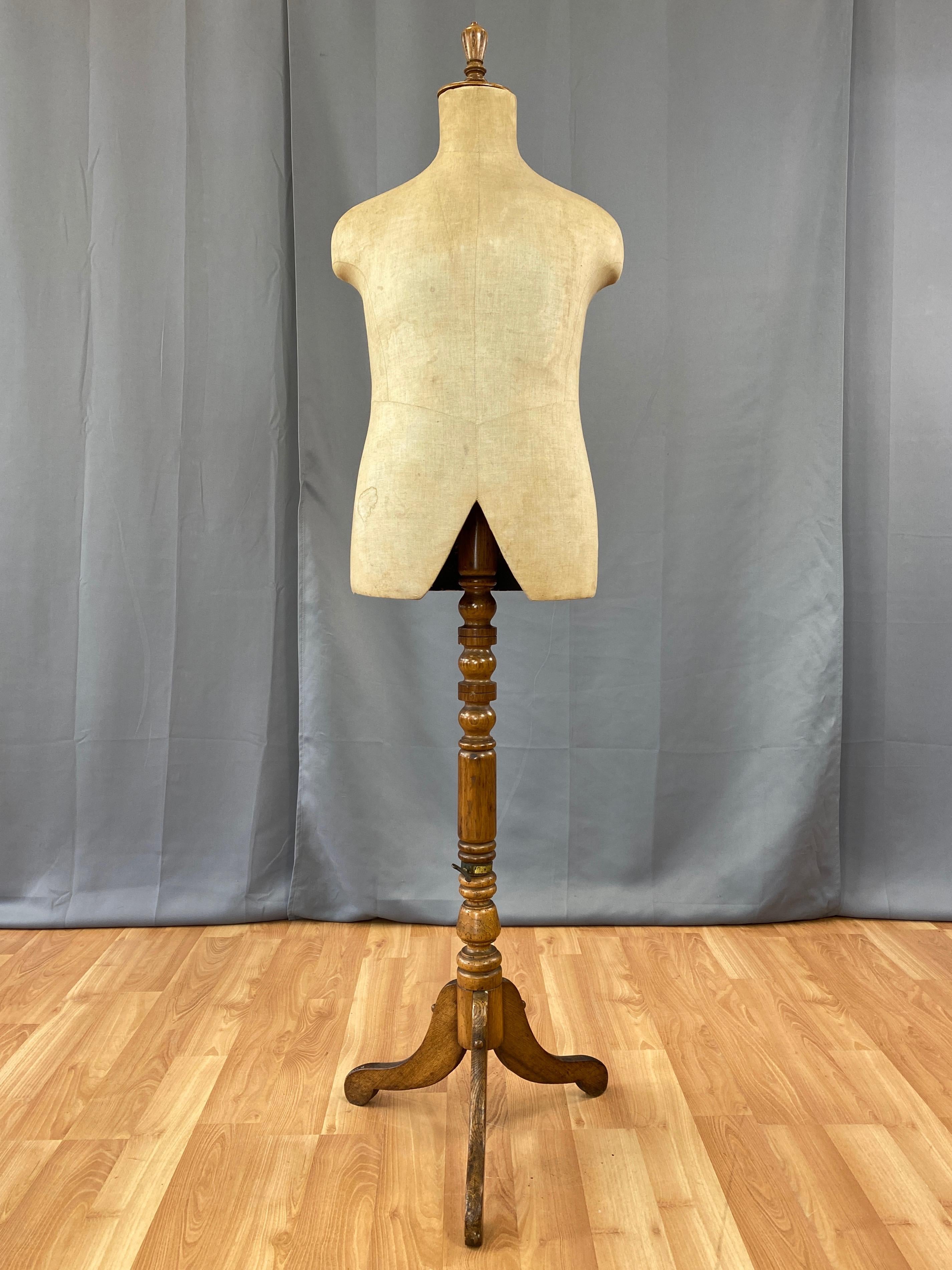 A very handsome circa 1910 adjustable height standing tailor’s mannequin, dummy, or retail display form by Harris & Sheldon Ltd. of Birmingham, England.

Tripod base with cabriole legs, lower section of stand, cap, and finial are oak, while upper