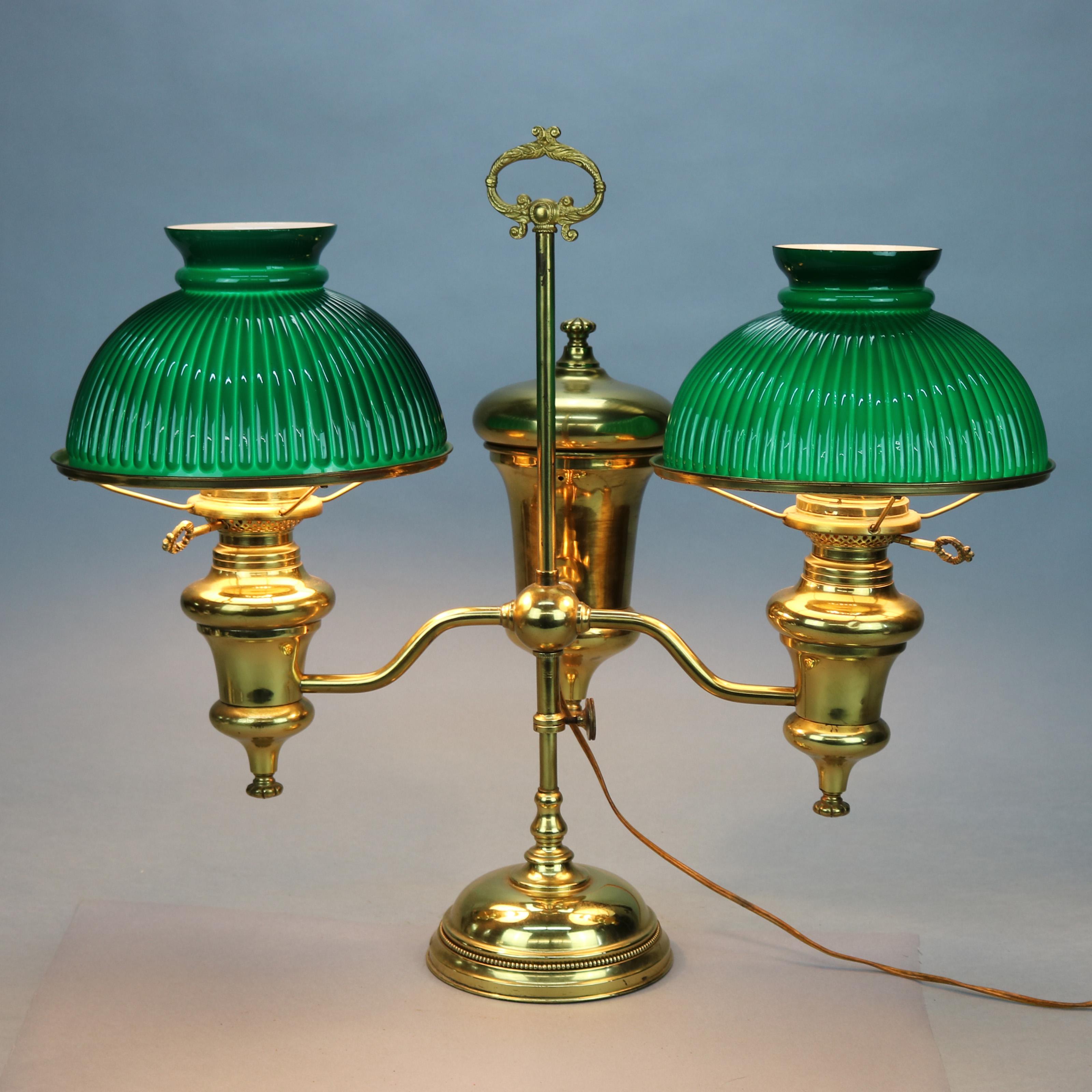 An antique Harvard School double student lamp offers adjustable brass base with urn fonts and two arms terminating in lamps with ribbed green ribbed cased glass shades, electrified, c1890

Measures: 22.75