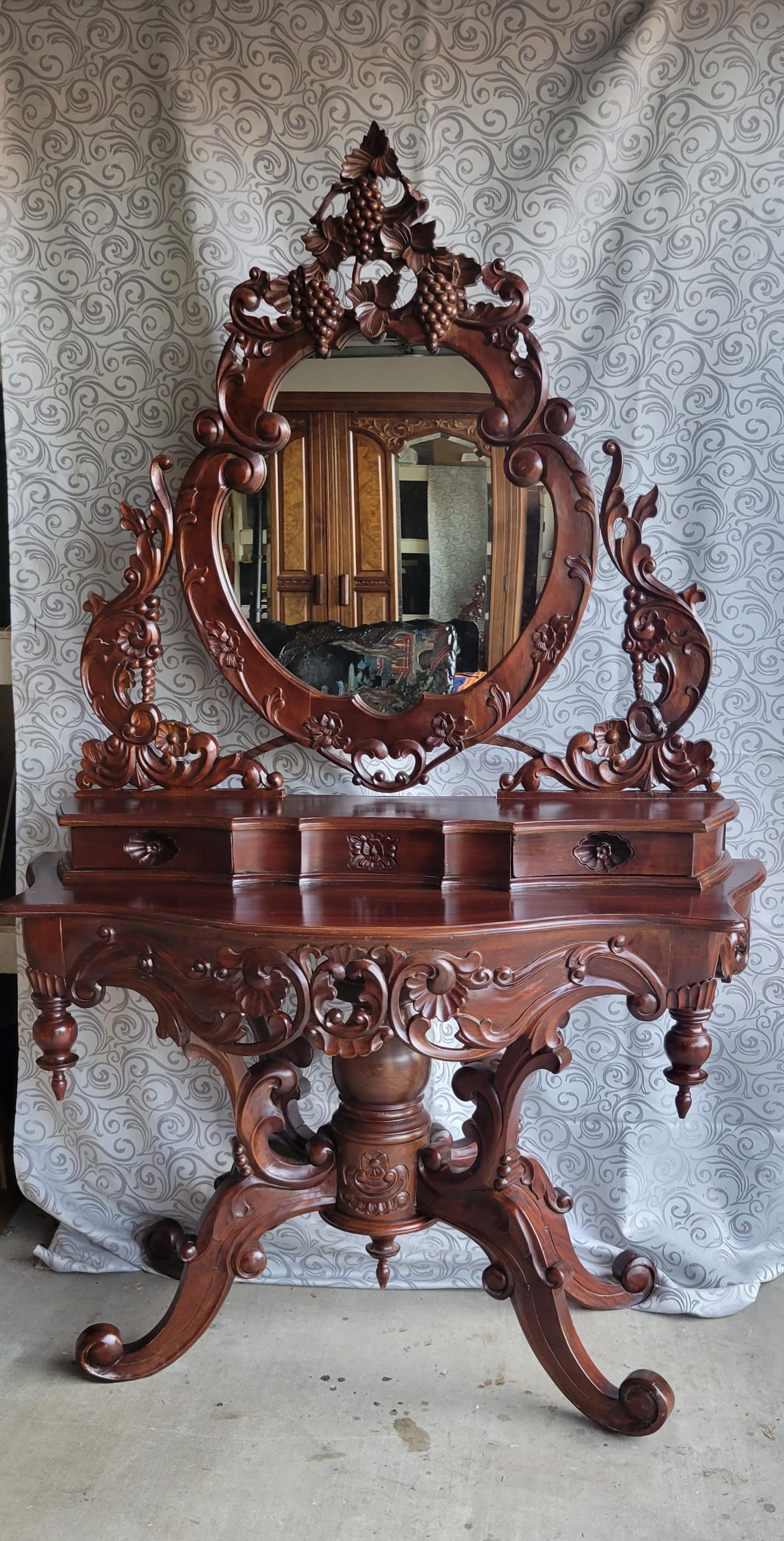 Vanité ancienne sculptée à la main avec deux tiroirs et un miroir ovale. Fabriqué en bois massif avec des sculptures complexes. La partie supérieure avec le miroir ne se sépare pas de la partie inférieure,  il est construit en une seule pièce.  Le