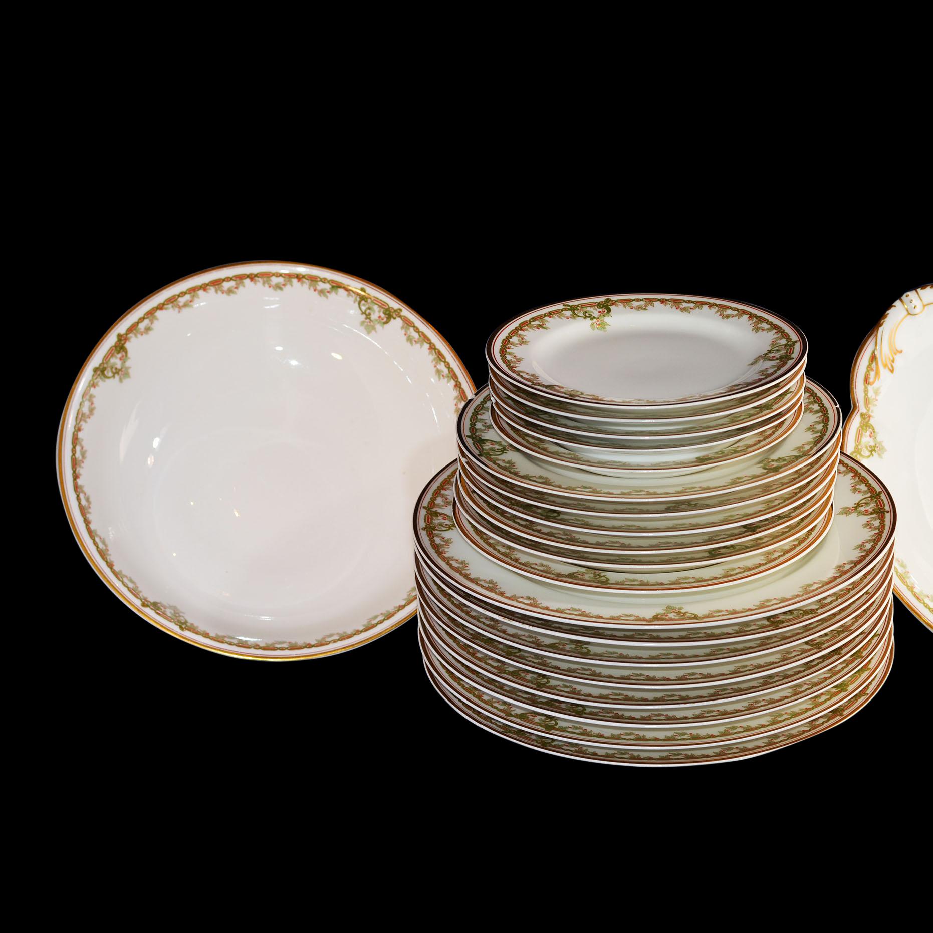 21 Piece set of Haviland dinner ware with 2 serving bowls. The design has a lovely gold rim with a greenery and berry design. We have not been able to identify the pattern, but the serveware is marked Underglaze Haviland, France in Green (circa