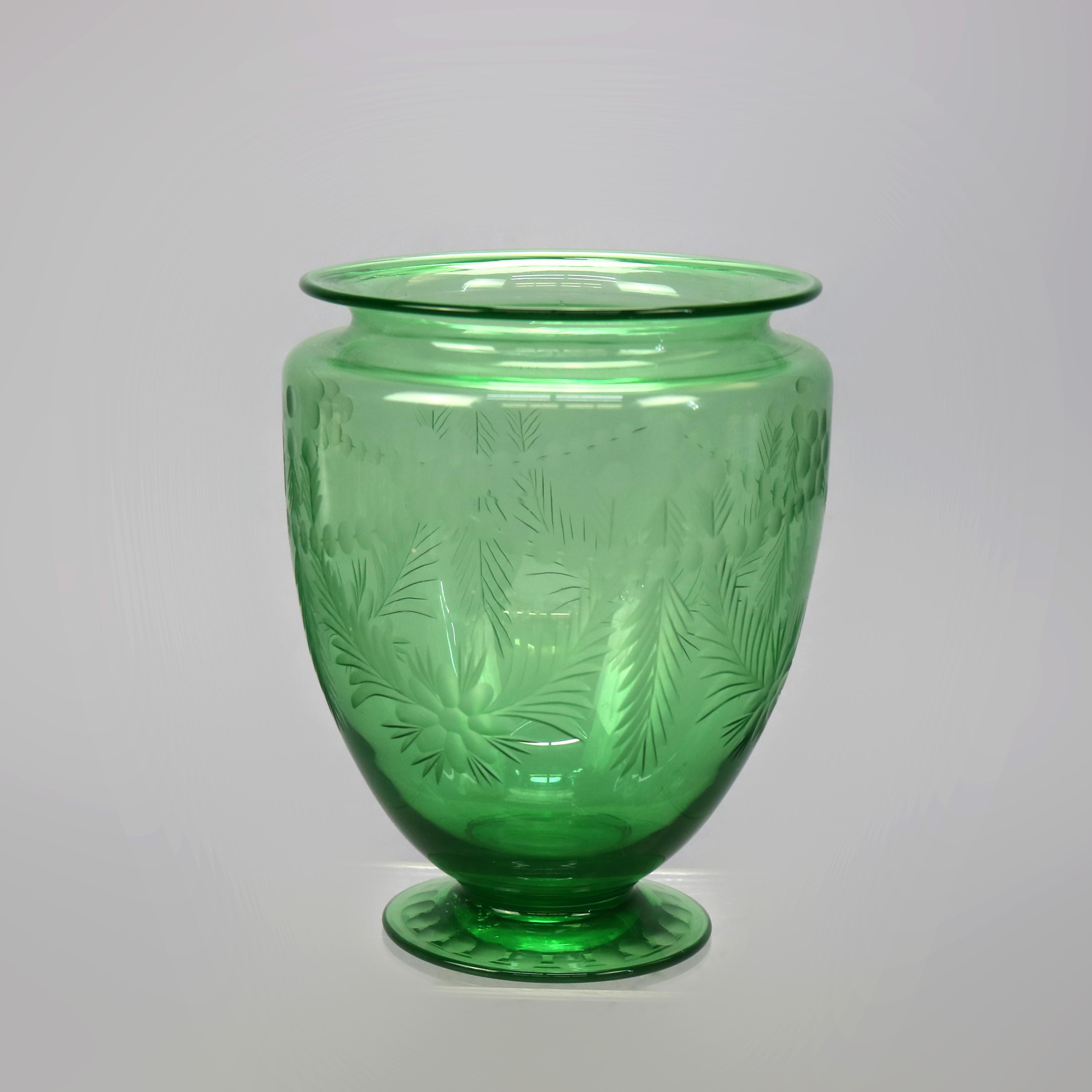 An antique vase by Hawkes or Sinclaire offers green glass construction with acid etched foliate design, raised on foot with repeating thumb print pattern, unsigned, c1930

Measures - 7''H x 5.5''W x 5.5''D.
