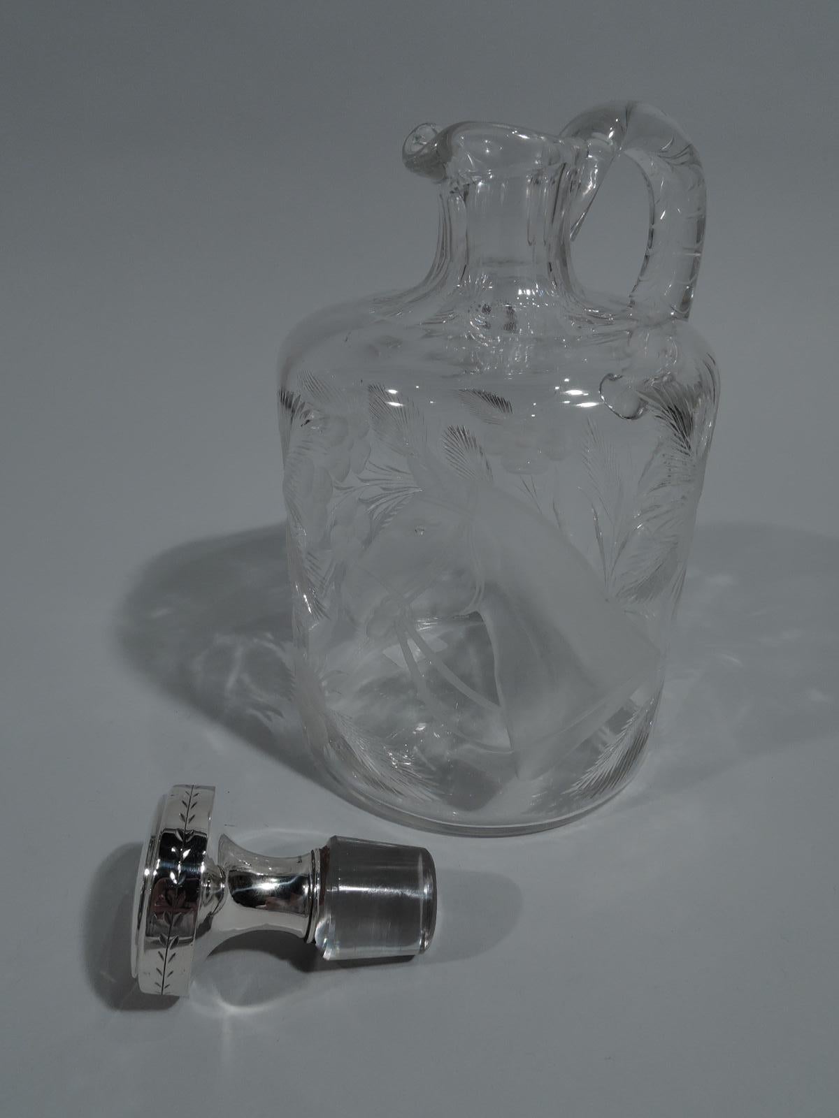 Edwardian glass and sterling silver decanter with horse motif. Made by TG Hawkes & Co. in Corning, New York, ca 1920. Drum form with curved shoulder, short faceted neck, and high-looping ring handle. Stopper sterling silver with flat top and spool