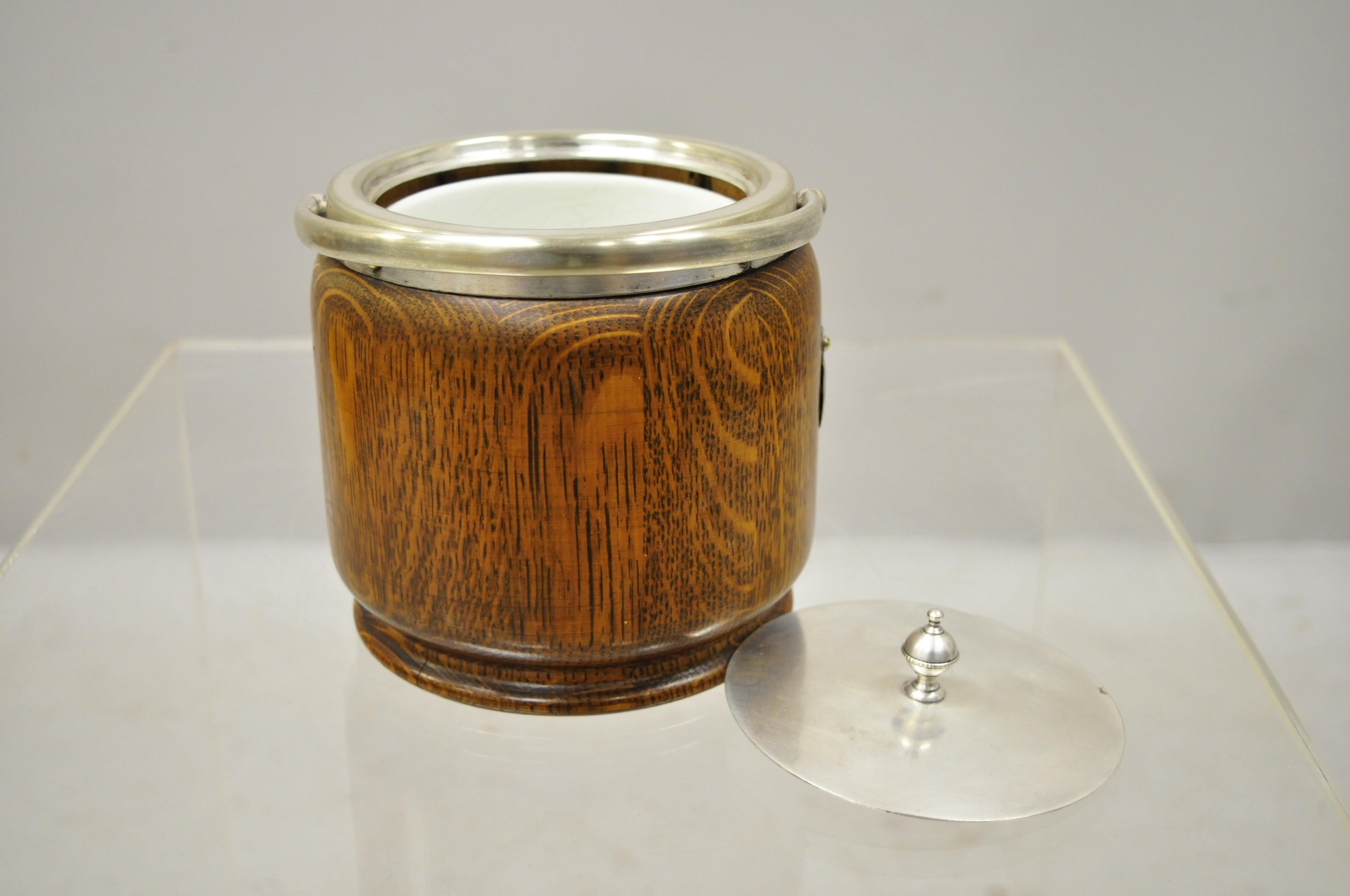 Antique H.C. & C. English silver plate and oak biscuit barrel with lid and liner. Item features silver plated ormolu, ironstone pottery lines, marked 