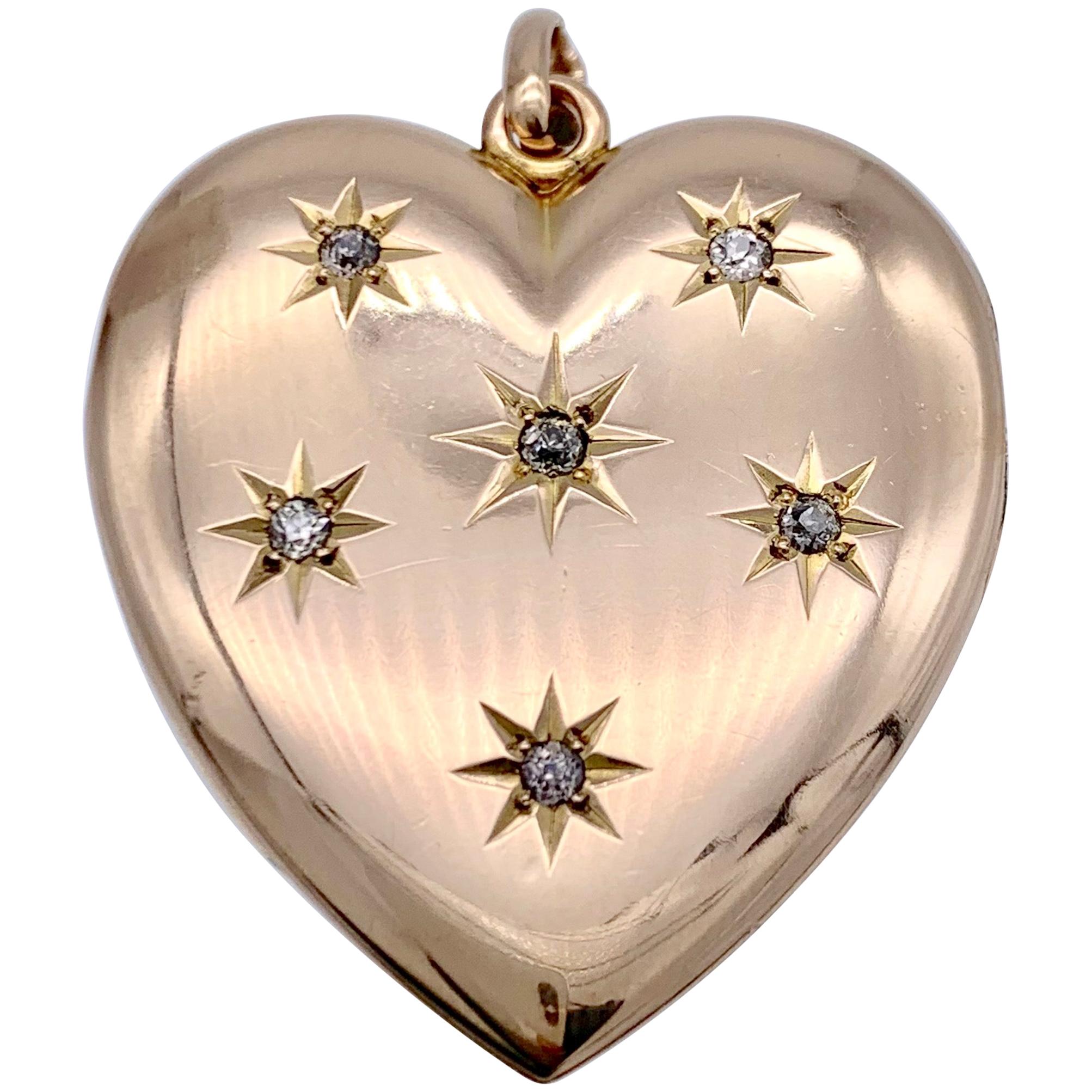 This elegant 14 karat rose gold locket in the shape of a heart is set with six diamonds in star shaped settings. The reverse is beautifully engraved with the initials H and M.