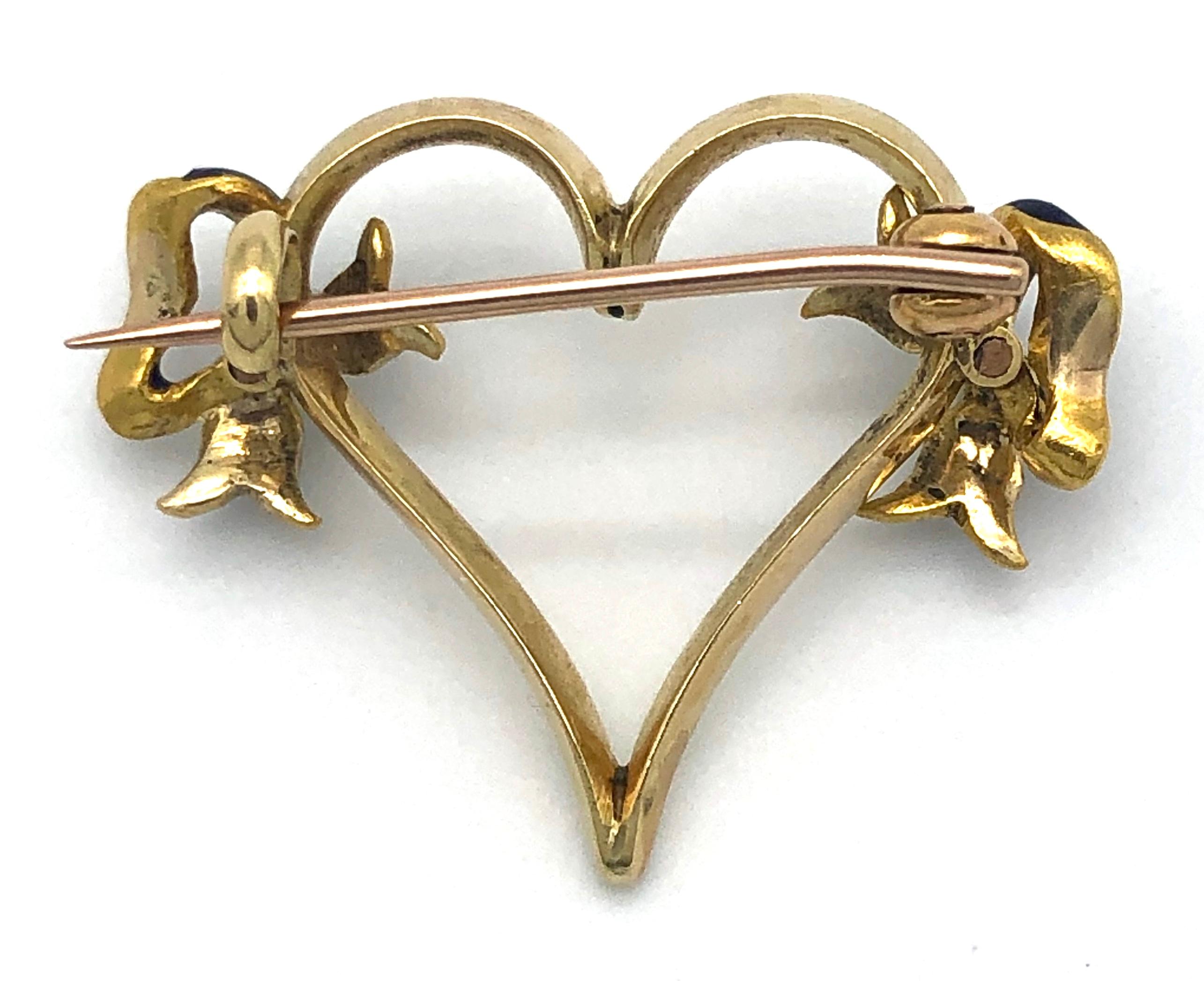 Charming Edwardian 14k gold brooch in the shape of a cream coloured enamelled heart with blue polka dots. The heart is decorated with two blue enamelled bows set with pearls.