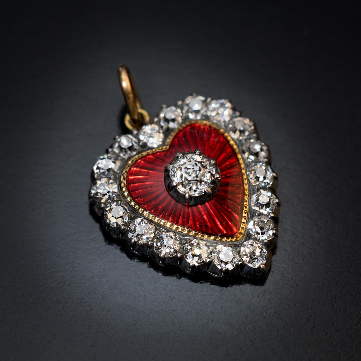 This Belle Époque, c.1890s, antique heart-shaped pendant is finely crafted in 18K gold and silver. The pendant features an excellent vivid red guilloche enamel and bright white chunky old mine cut diamonds.

Estimated total diamond weight is 0.64