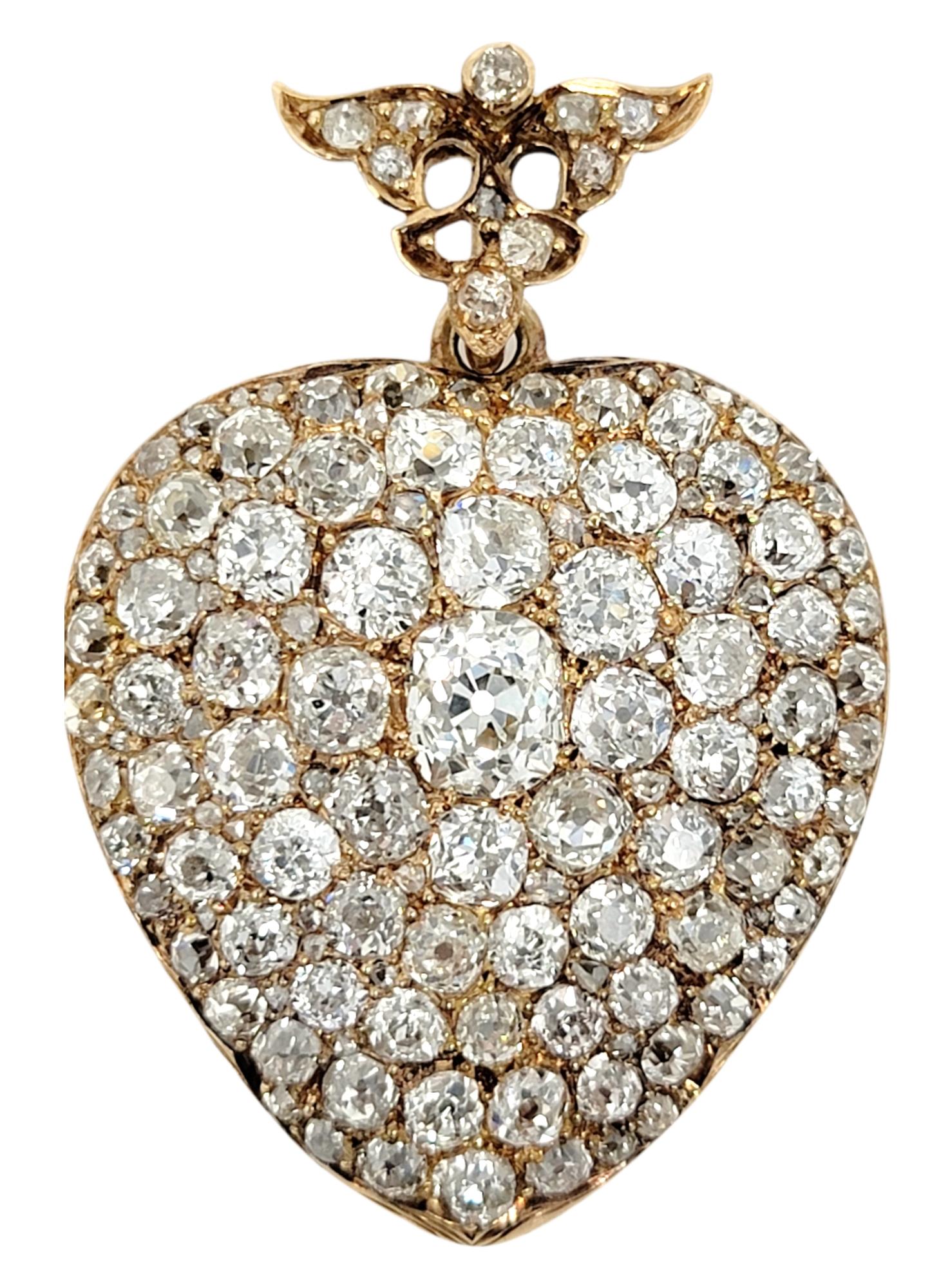 Absolutely exquisite antique heart pendant/locket combo embellished with stunning Old Mine and Old European cut natural diamonds in varying sizes. The glittering white diamonds really pop against the yellow gold, while the slightly rounded layout of
