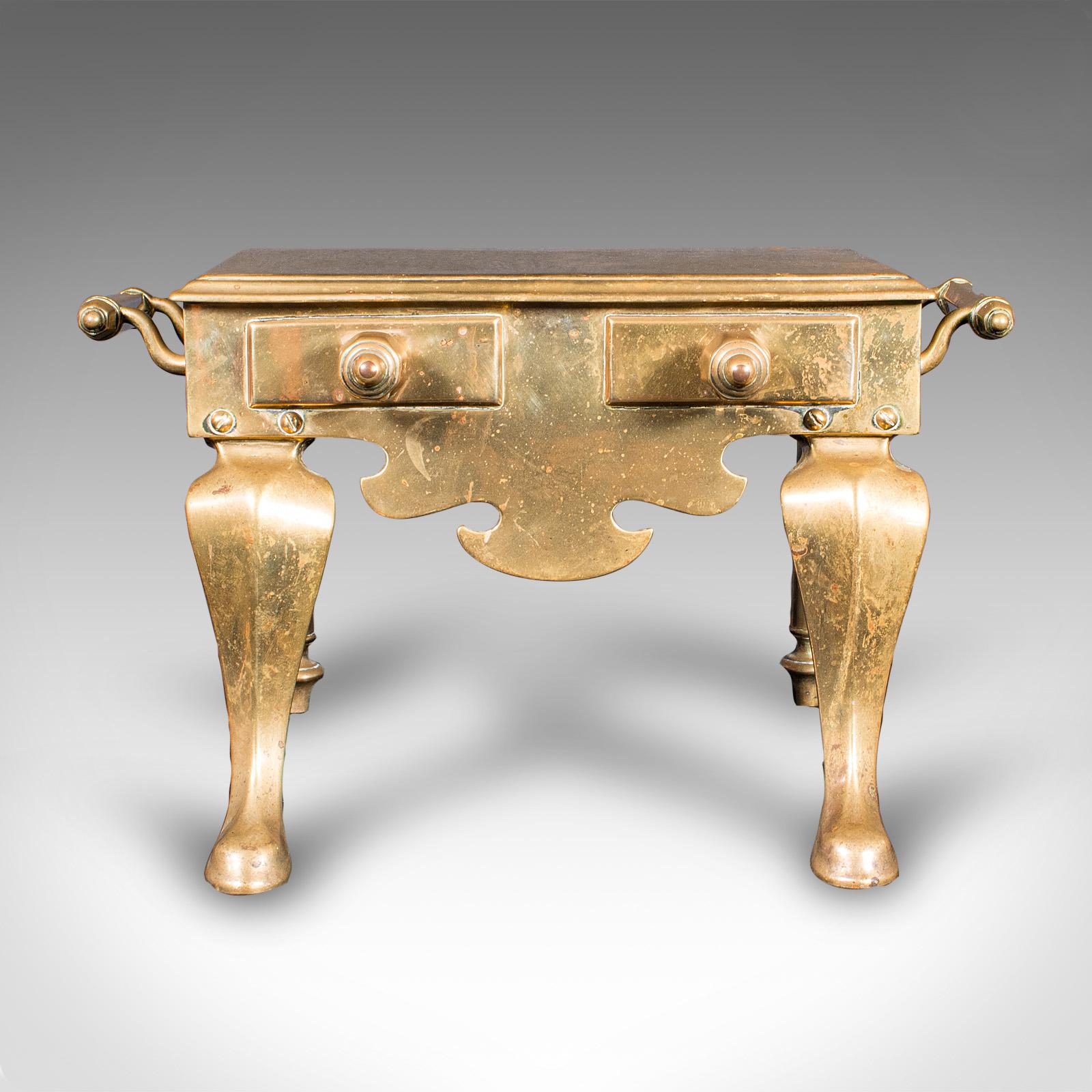Questo è un antico cameriere da focolare. Uno scaldavivande o sottopentola inglese in ottone, risalente al tardo periodo vittoriano, circa 1900. Un pezzo da caminetto affascinante e decorativo con un'influenza georgiana e un eccellente dettaglio del