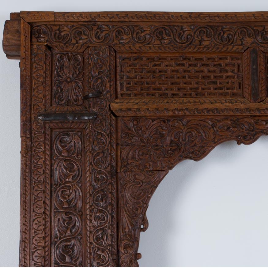 This remarkable late 19th century doorway surround from Rajasthan in NW India, is covered in the traditional carved geometric and floral designs of the era. The large iron hoops that were used as door hinges remain on the back, which is not carved.