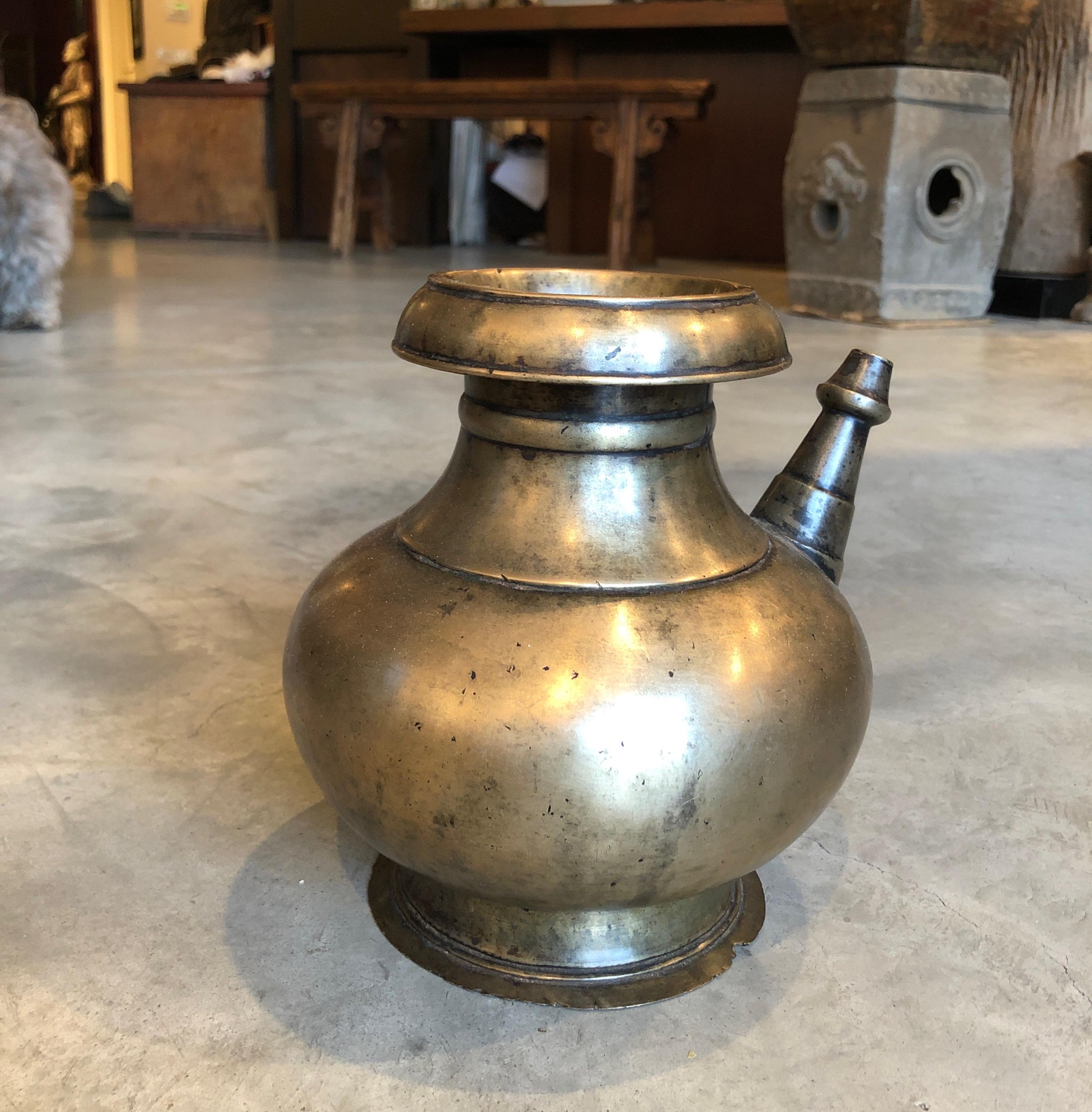 A beautifully cast and unusually tall, large and heavy mid-19th Century bronze ceremonial holy water decanter from Nepal. This truly graceful design features a gorgeous patina, emphasizing it's many years of use in a Buddhist temple. This is a