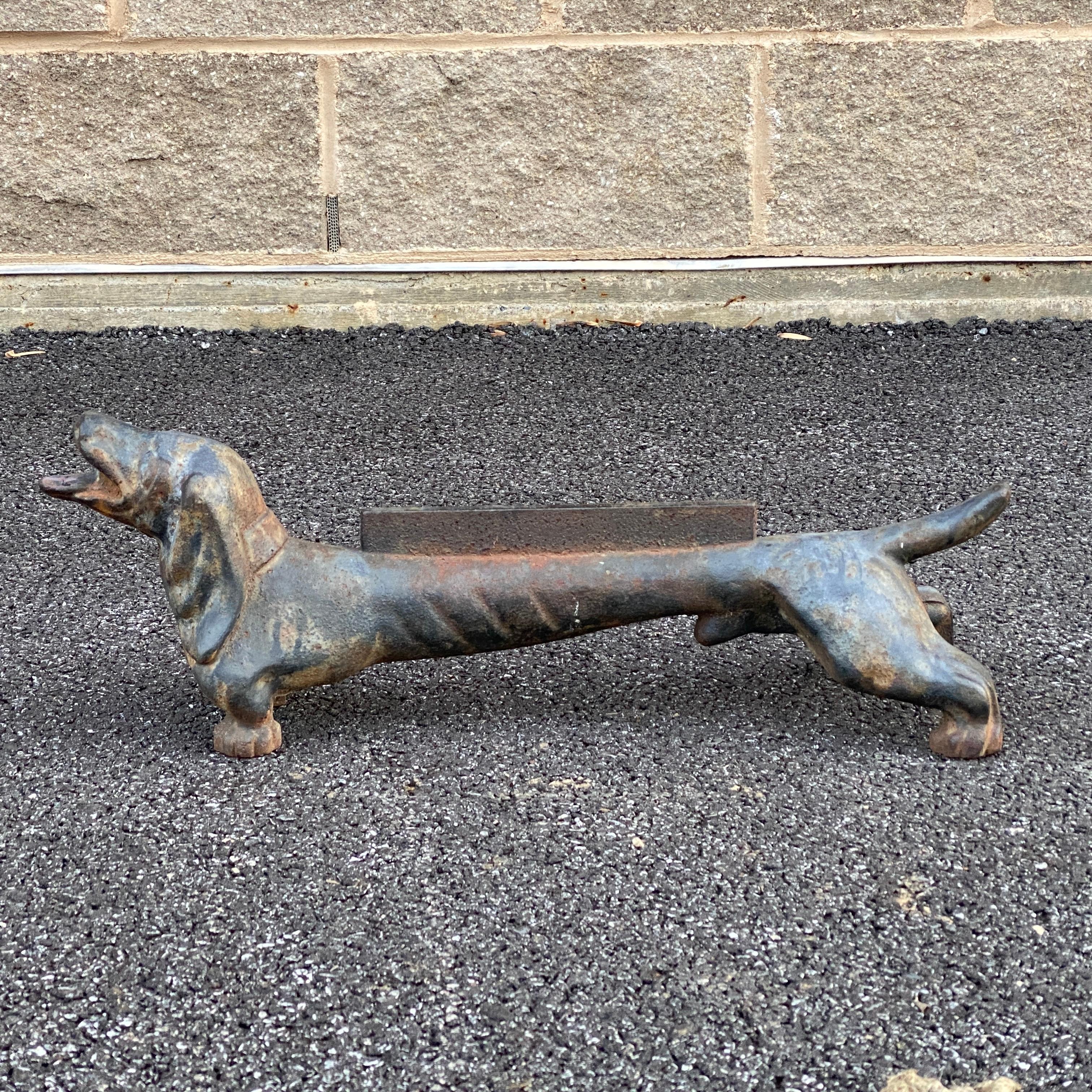 An antique heavy cast iron boot scraper in the from of a dachshund dog. Scraper section is 9.25” long