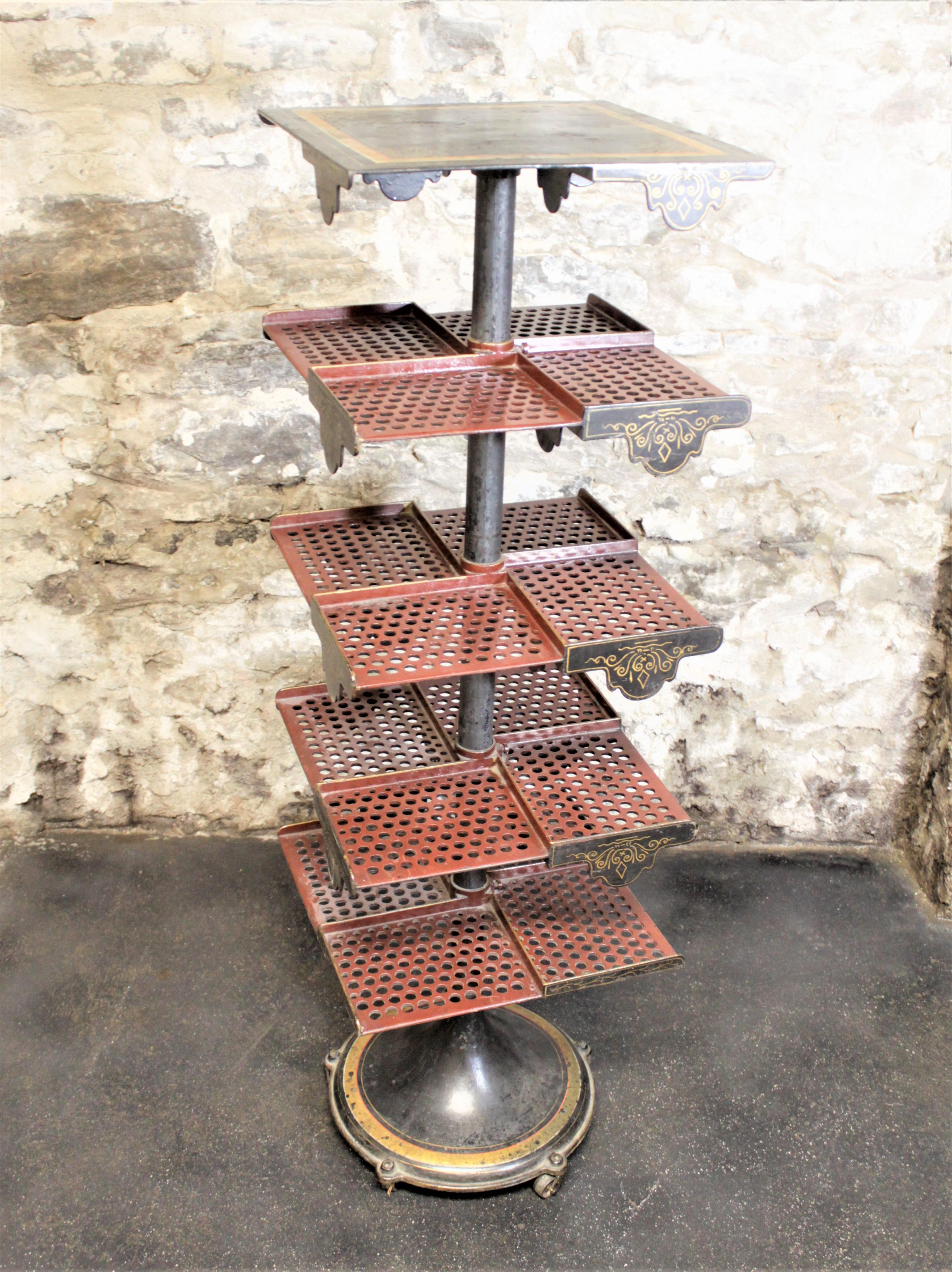 This very heavy and substantial cast metal book mill is presumed to have been made in the United States in circa 1880 in the Victorian style and used as a store display stand. This bookcase is just over four feet tall and has four tiers with four