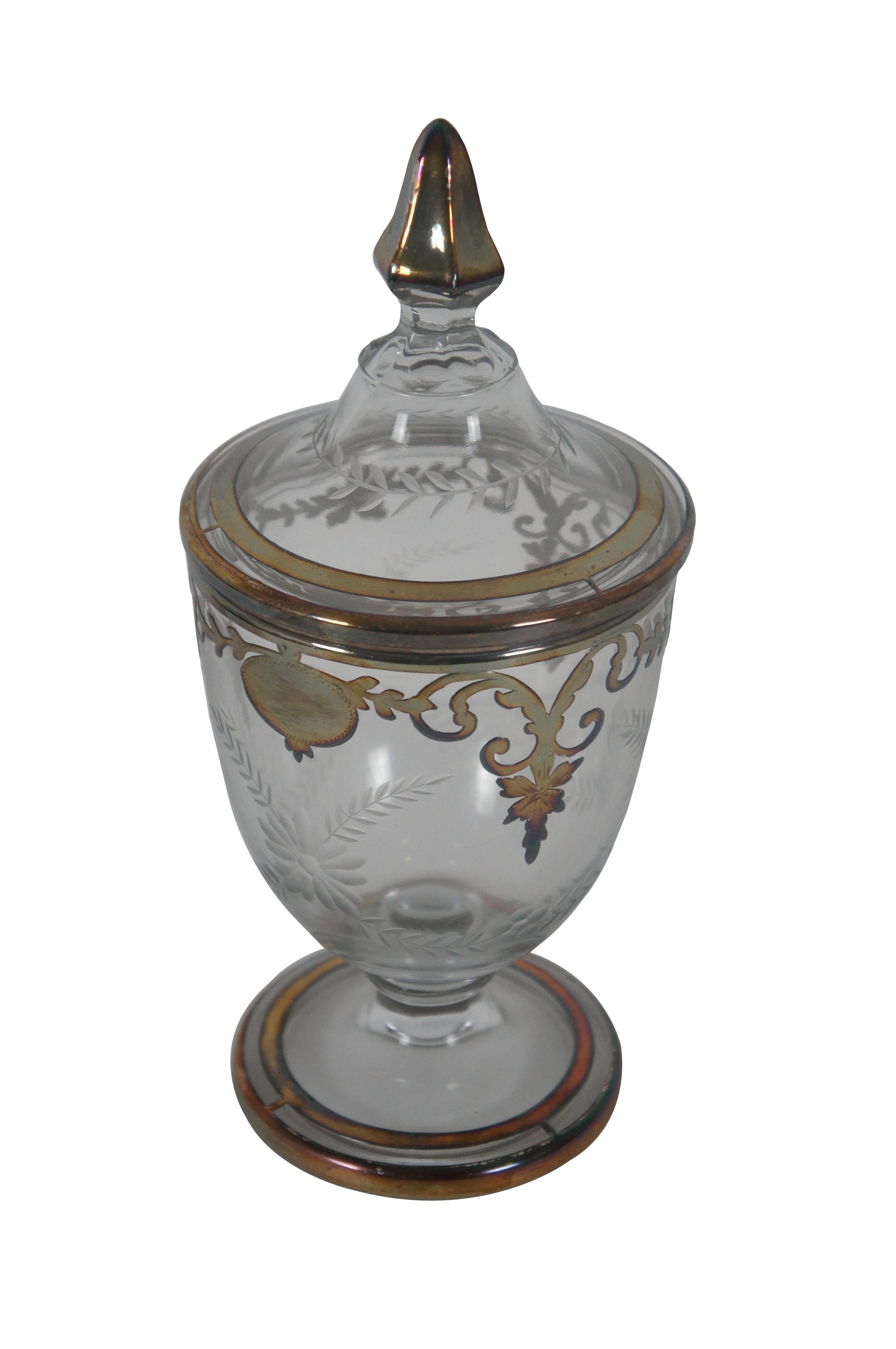 Antique Heisey pressed and etched glass candy jar / compote featuring trophy urn form with footed pedestal base, baroque sterling silver overlay and lidded top with finial.

Dimensions:
4.25
