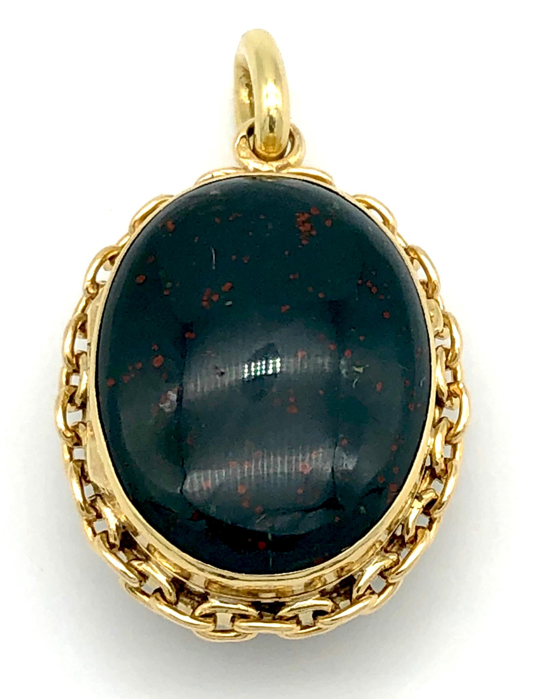 This charming 18kt gold locket has two oval bloodstone cabochons on either side of the pendant. The edge is decorated with chain links. 
On the inside of the locket is a hinged gold frame with glas. 
This small but chunky piece of jewellery is also