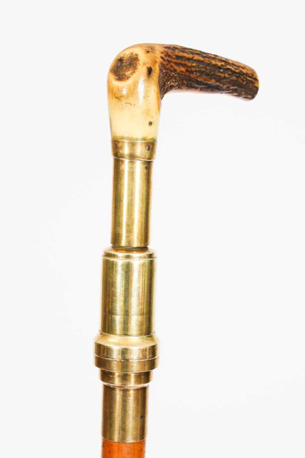 This is a beautiful antique English brass helixophile's novelty system gadget walking stick, circa 1880 in date.
 
The striking walking stick features an L-shaped stag antler handle with a built in novelty brass cork scew, on a malacca tapering