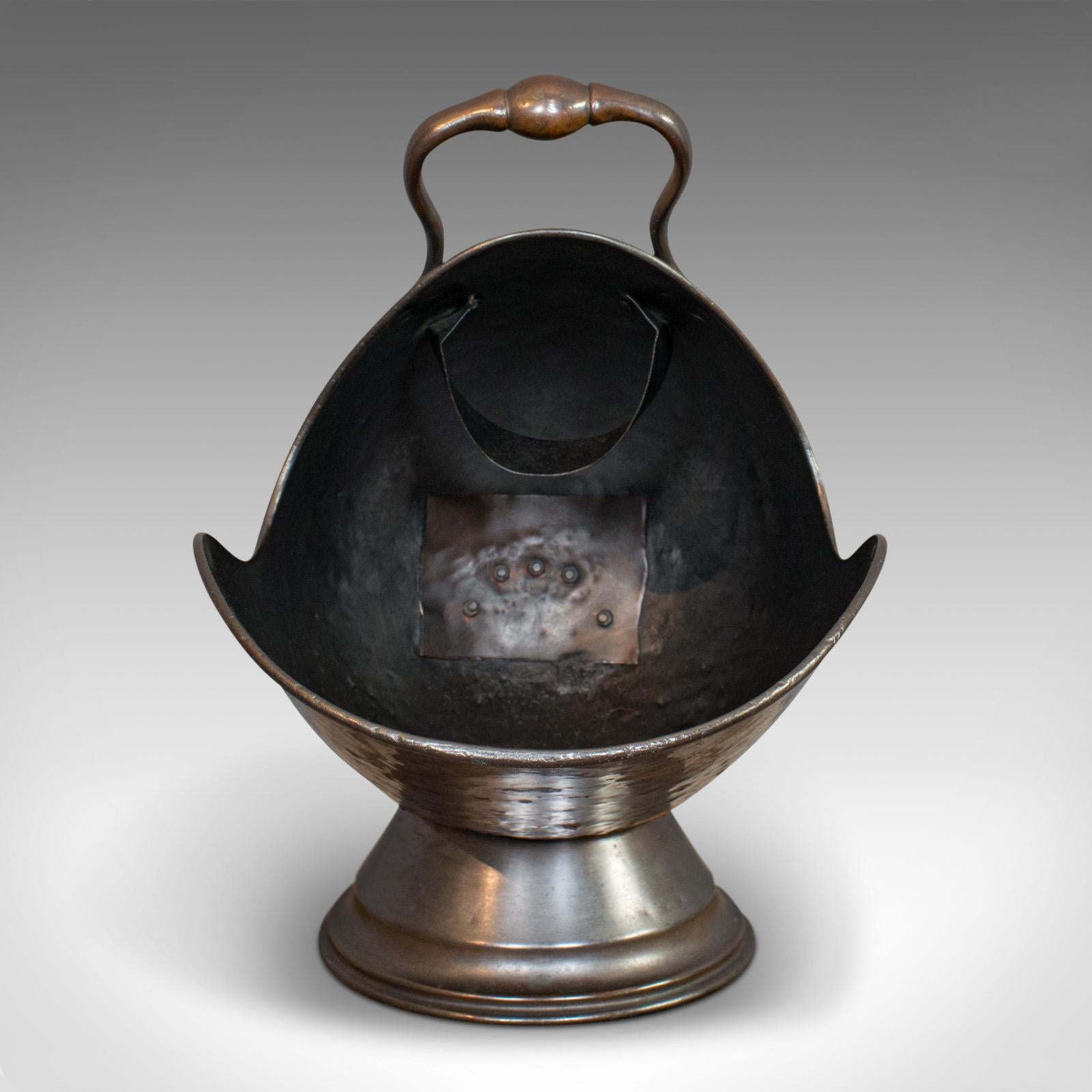 This is an antique helmet coal scuttle. An English, copper fireside log bucket, dating to the Victorian period, circa 1880.

Displays a desirable aged patina
Rich copper tones and hues
Complete with copper coal scoop and elegant brass fire