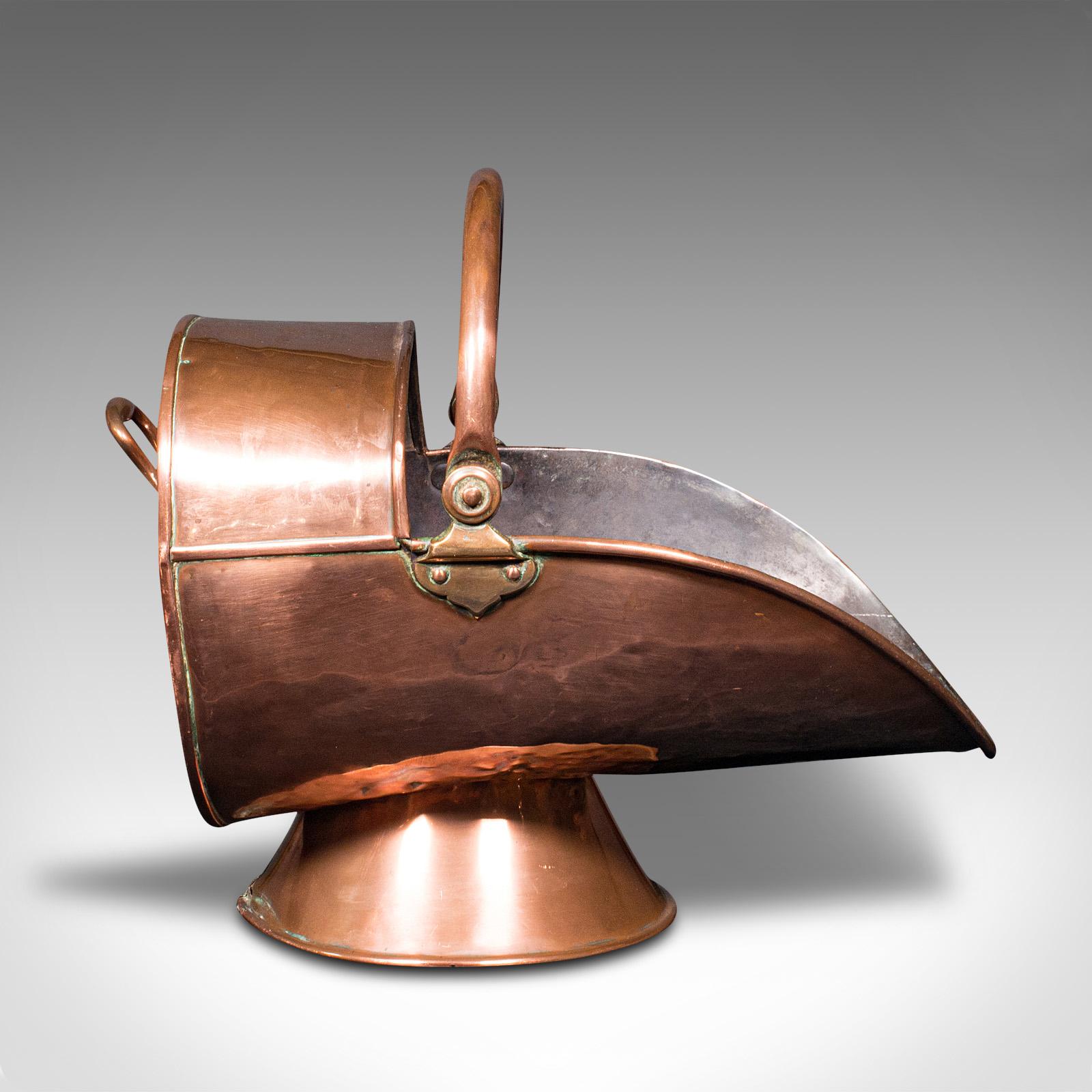 Il s'agit d'un ancien brasero à casque. Un scuttle ou bac à charbon anglais en cuivre, datant de la période victorienne, vers 1870.

Délicieux scuttle en forme de casque avec une brillance agréable
Présente une patine vieillie souhaitable sur