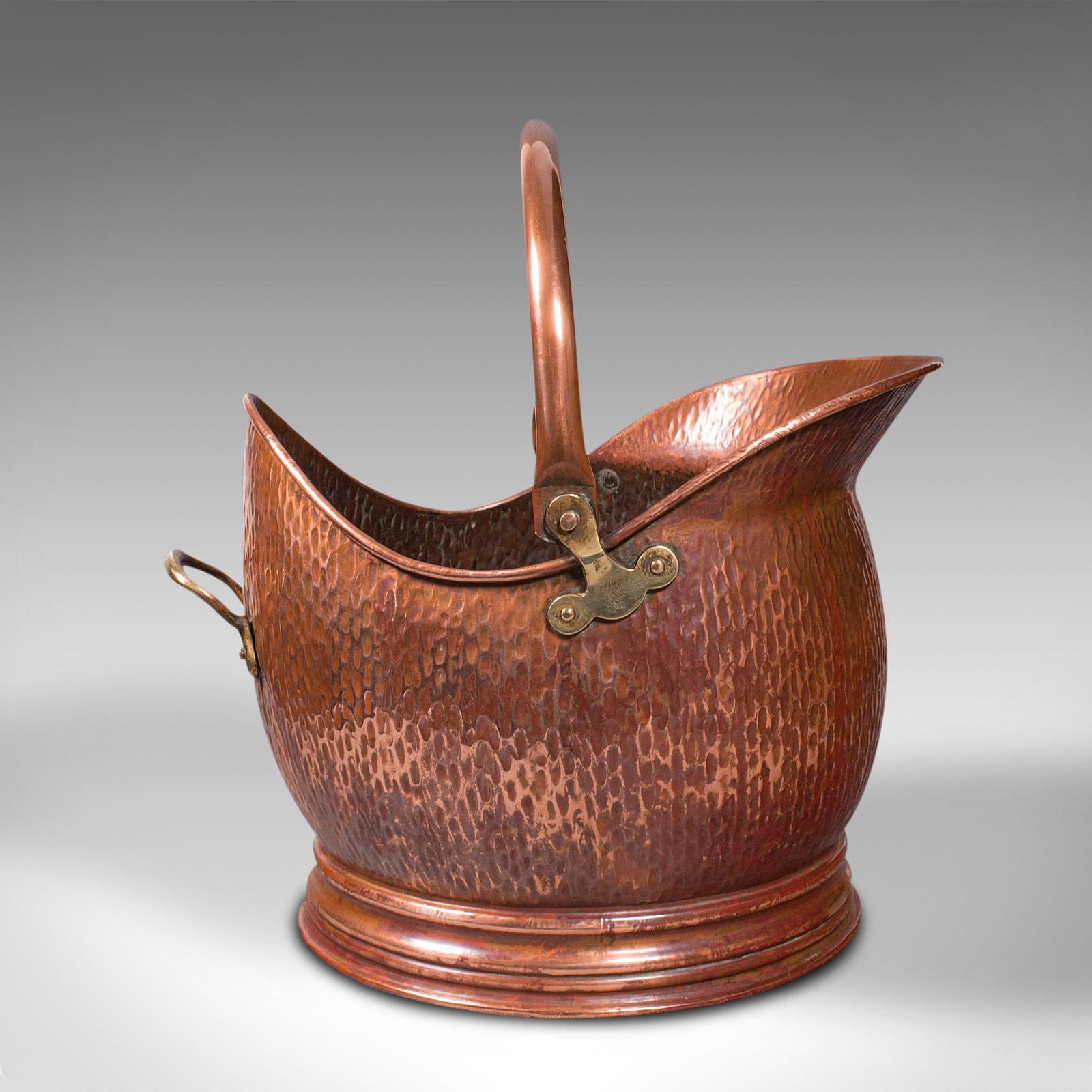 This is an antique helmet scuttle. An English, copper coal bucket or fireside bin, dating to the Edwardian period, circa 1910.

Delightful helmet shaped scuttle with appealing beaten finish
Displays a desirable aged patina and in good order
Copper